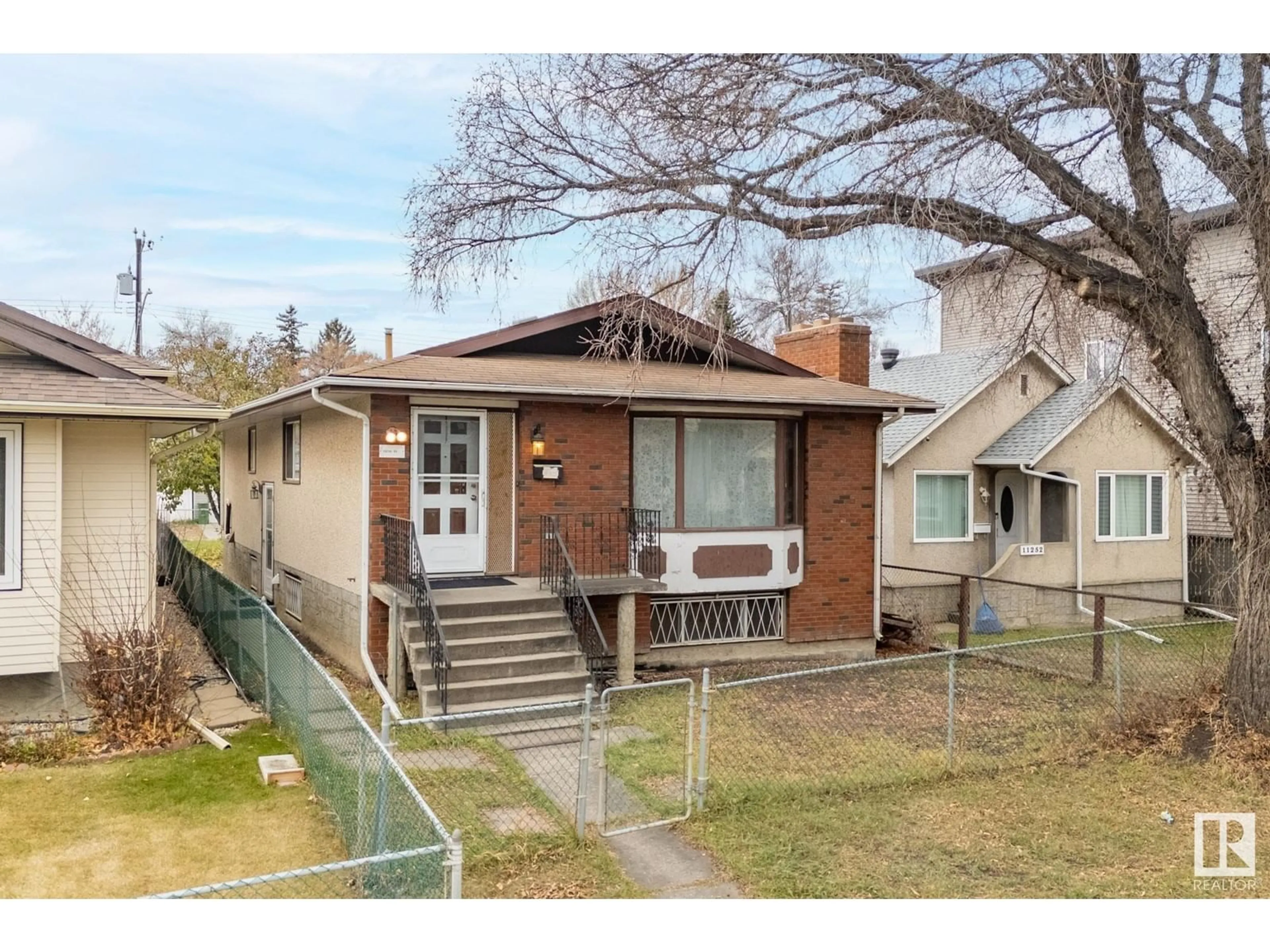 Frontside or backside of a home, the fenced backyard for 11250 95 Street ST NW NW, Edmonton Alberta T5G1K9