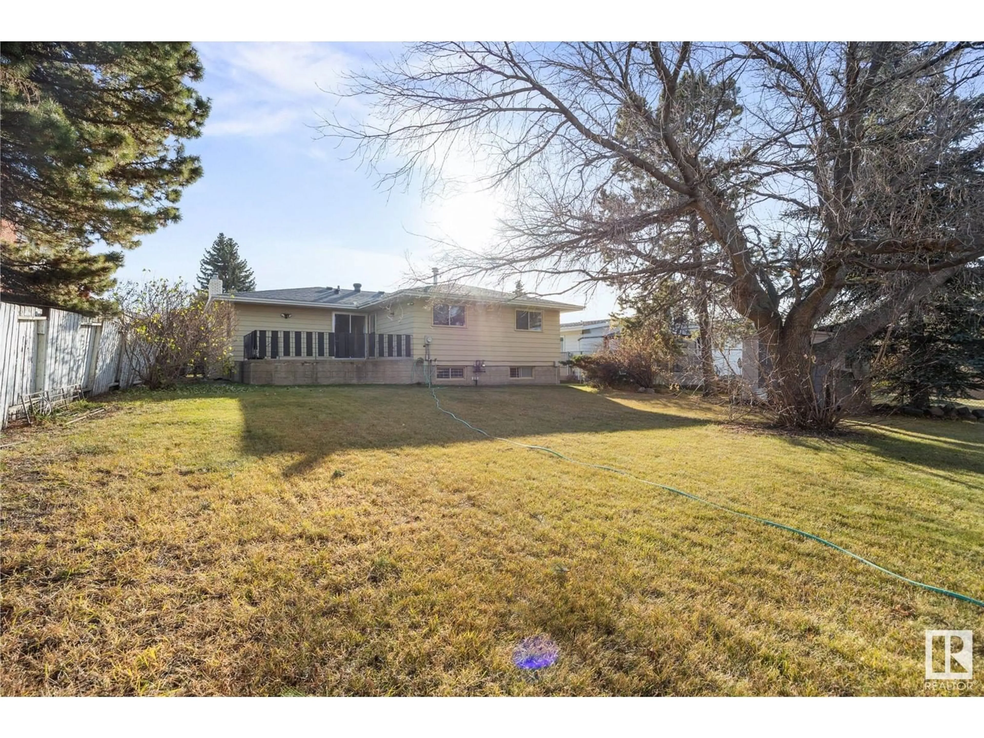 Frontside or backside of a home, the fenced backyard for 7912 44 AV NW NW, Edmonton Alberta T6K0Z2