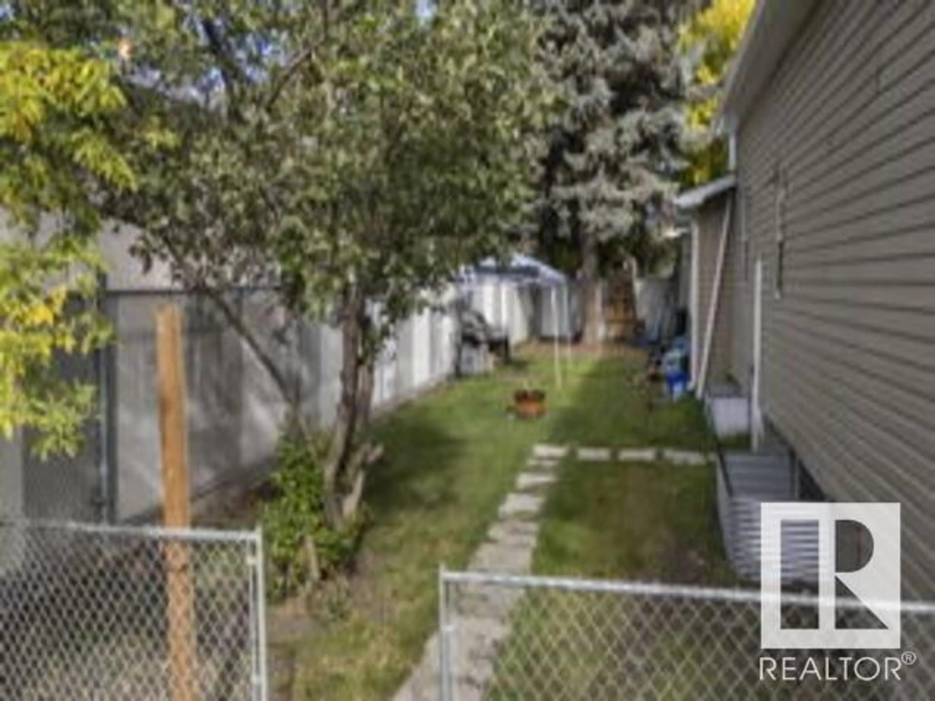 Frontside or backside of a home, the fenced backyard for 12524 129 AV NW, Edmonton Alberta T5L3J5