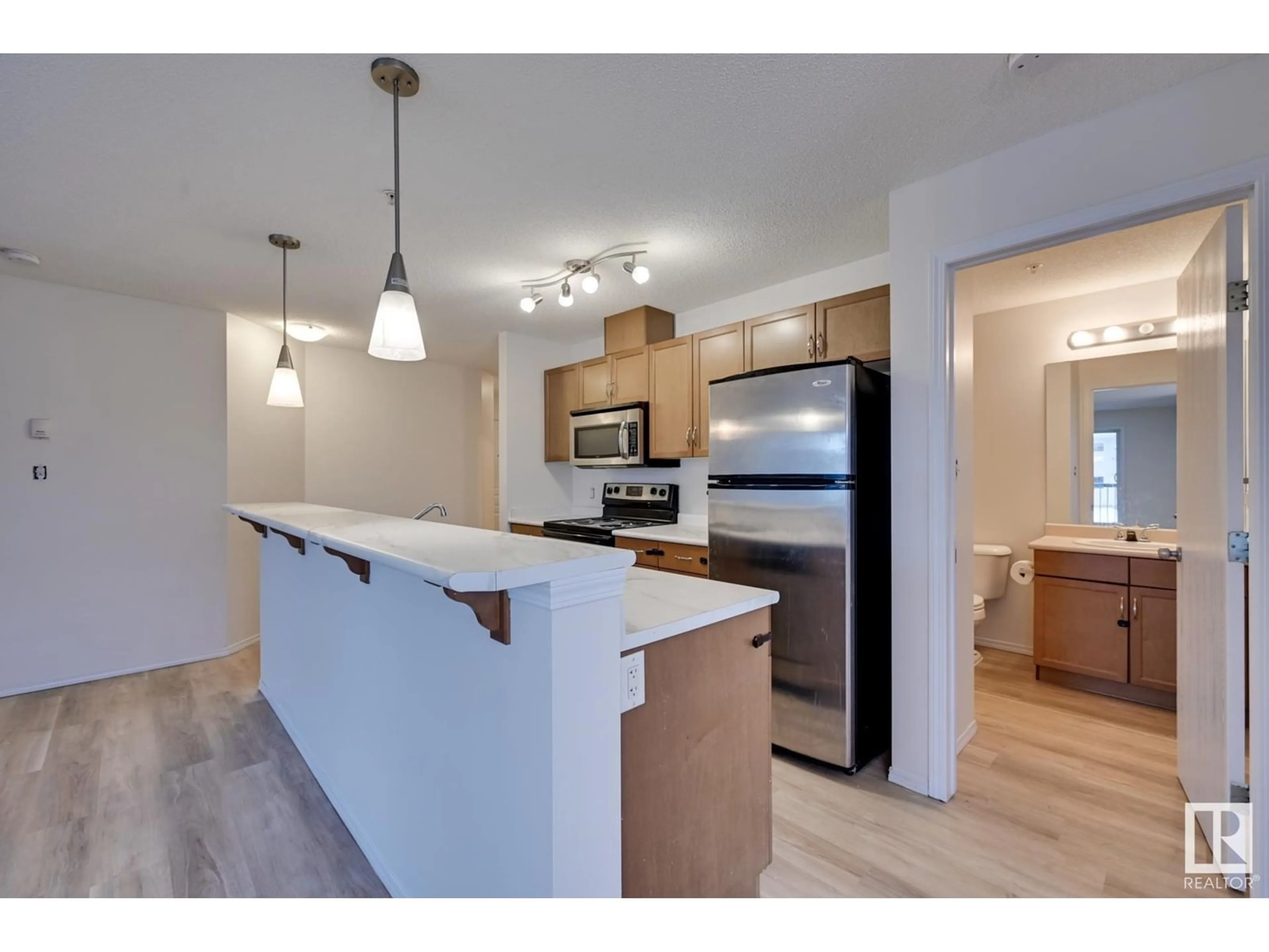 Open concept kitchen, wood/laminate floor for #218 1180 HYNDMAN RD NW, Edmonton Alberta T5A0P8