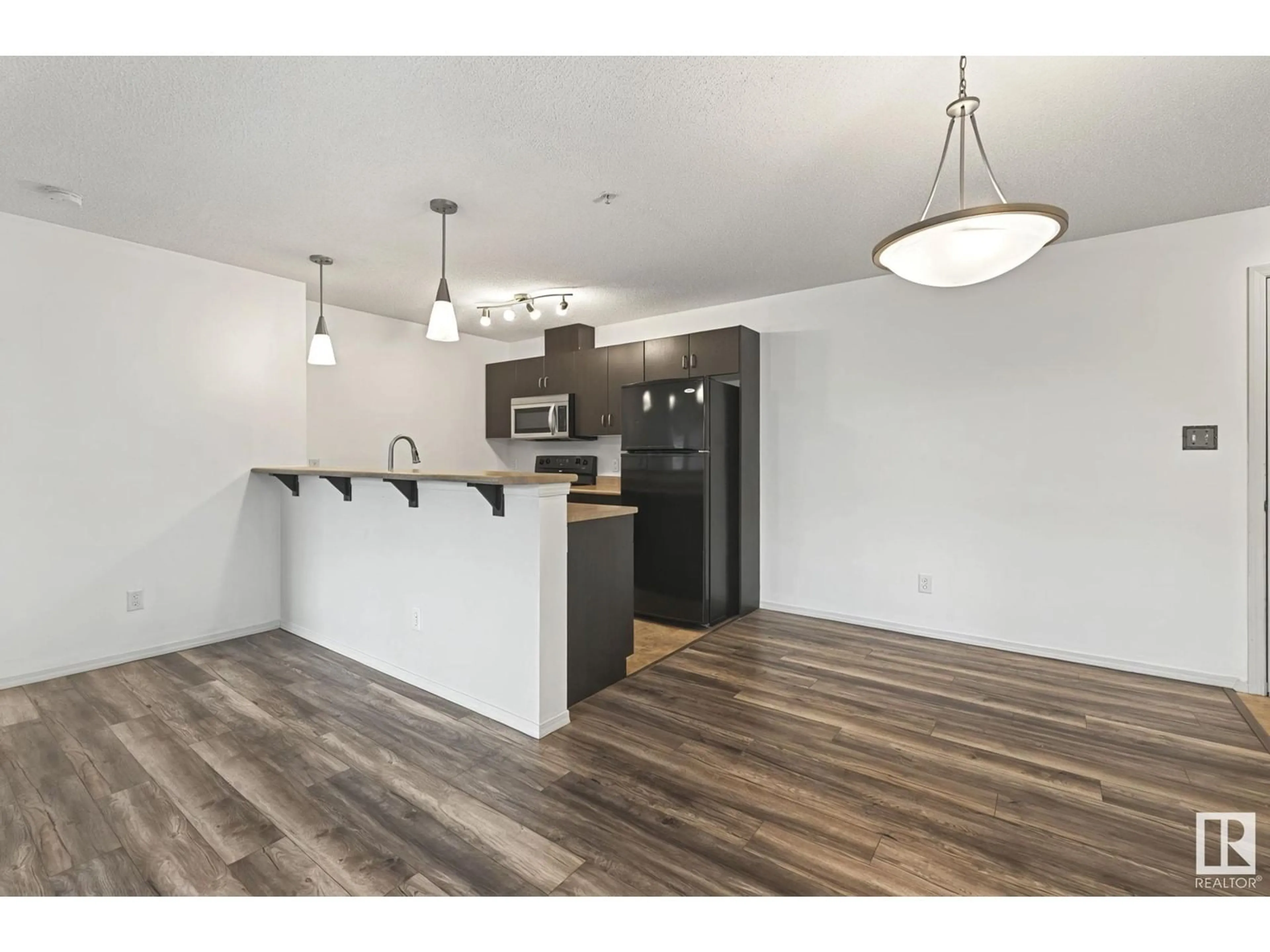 Open concept kitchen, wood/laminate floor for #306 1188 HYNDMAN RD NW, Edmonton Alberta T5A0E9