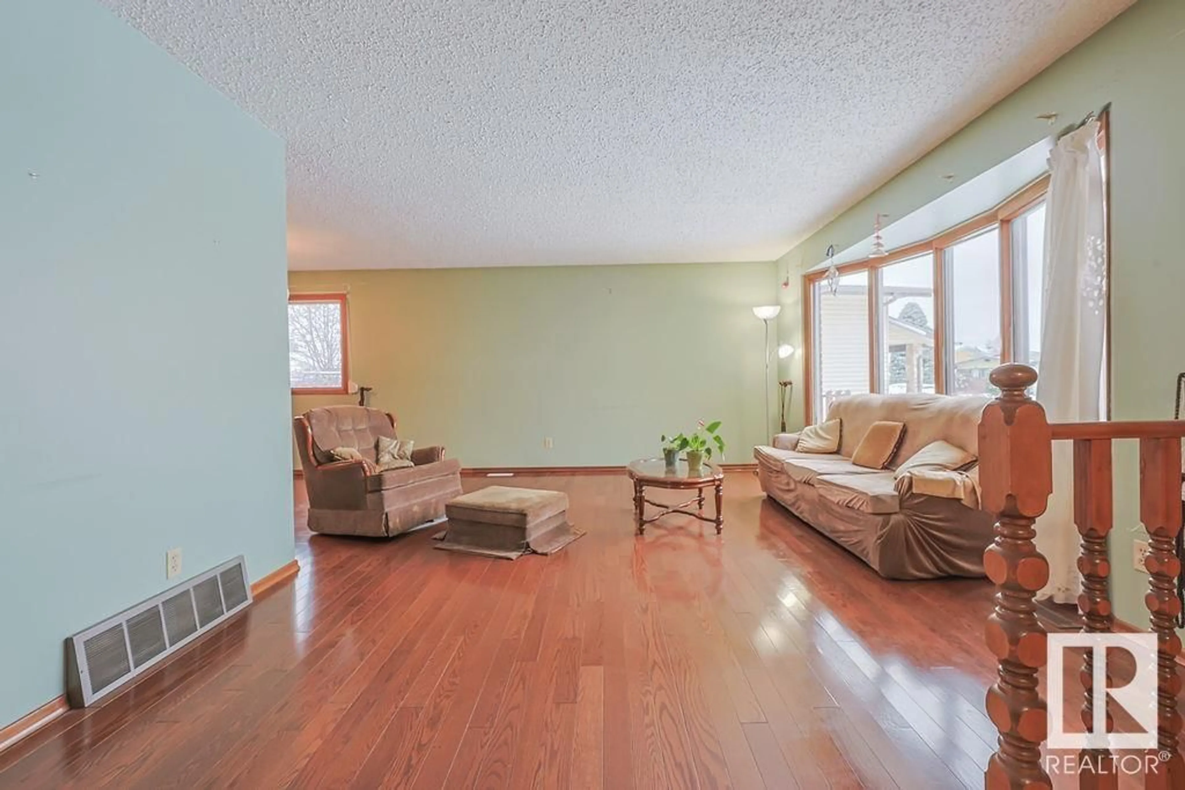 Living room with furniture, wood/laminate floor for 8416 150 AV NW, Edmonton Alberta T5E6E1