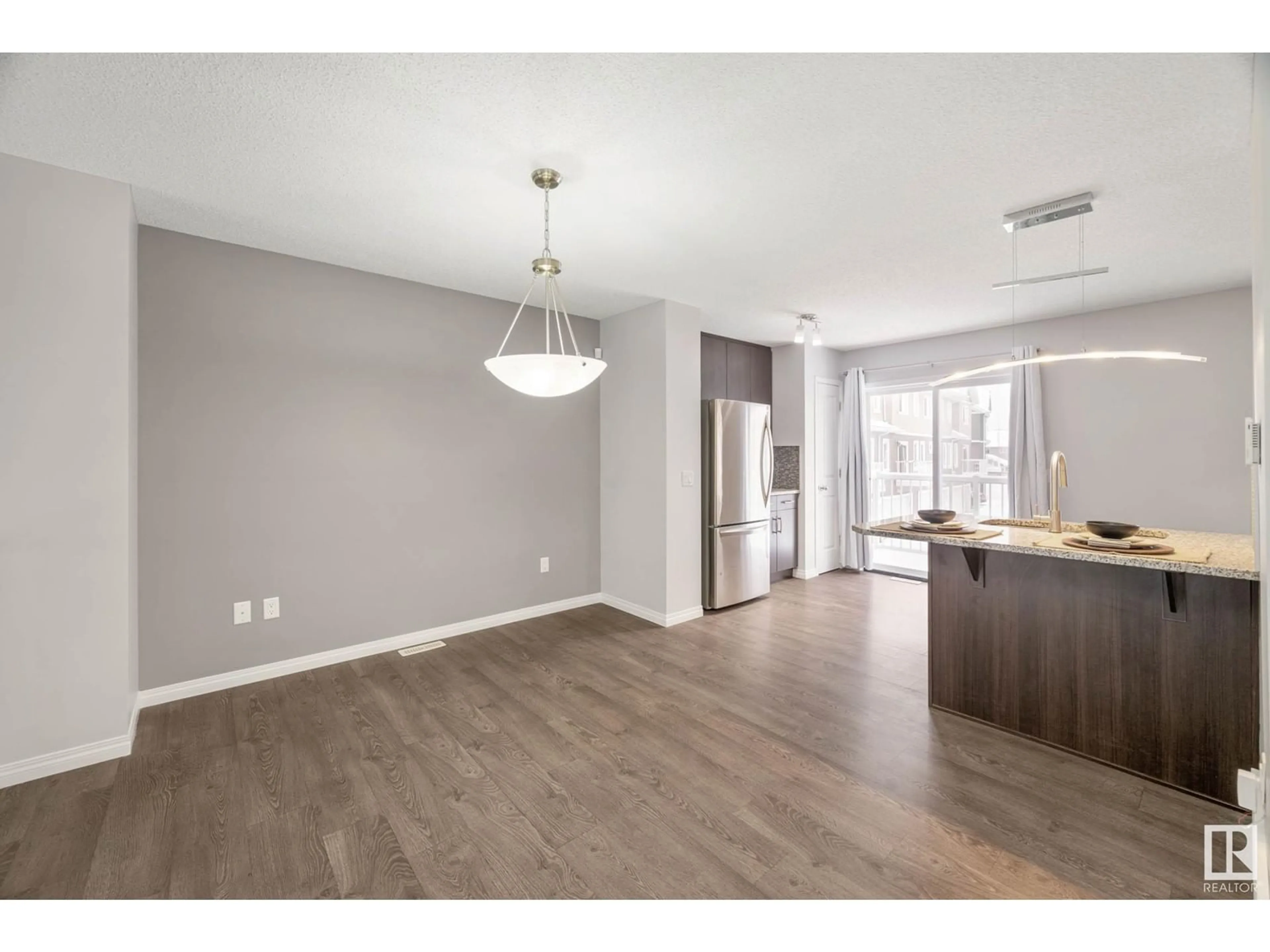 Open concept kitchen, wood/laminate floor for #15 4050 SAVARYN DR SW, Edmonton Alberta T6X1R8