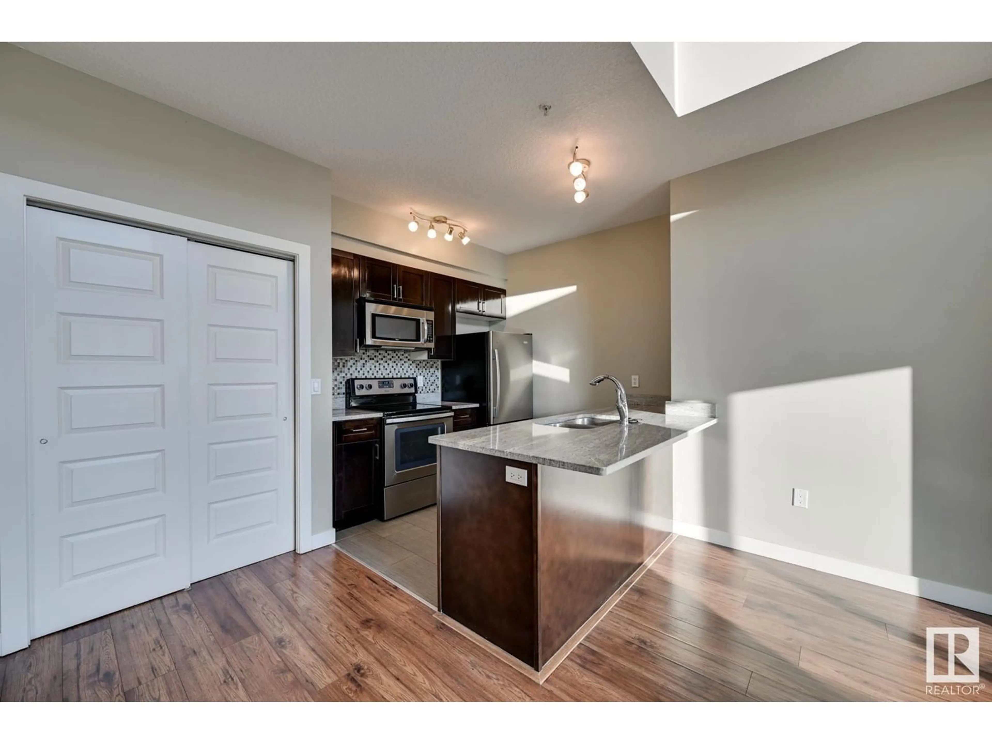 Open concept kitchen, wood/laminate floor for #505 1238 Windermere WY SW, Edmonton Alberta T6W2J3