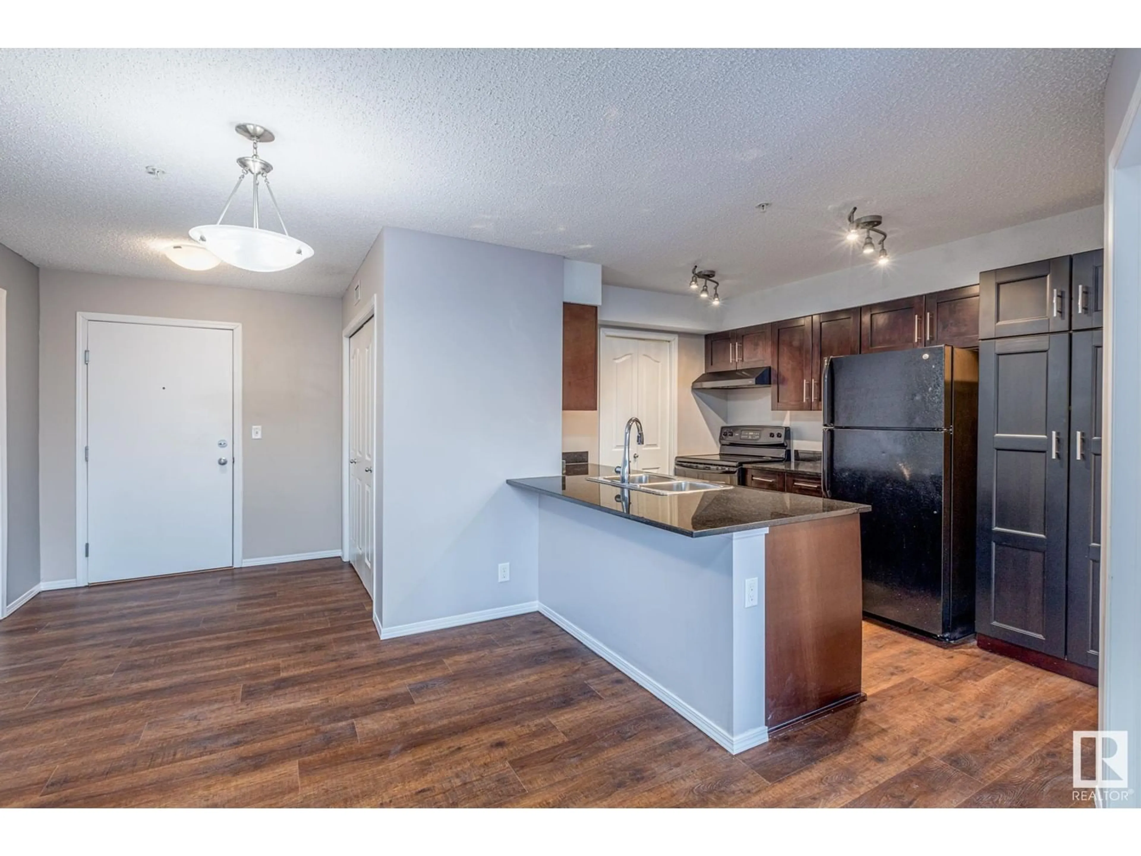 Open concept kitchen, wood/laminate floor for #107 11804 22 AV SW, Edmonton Alberta T6W2A2