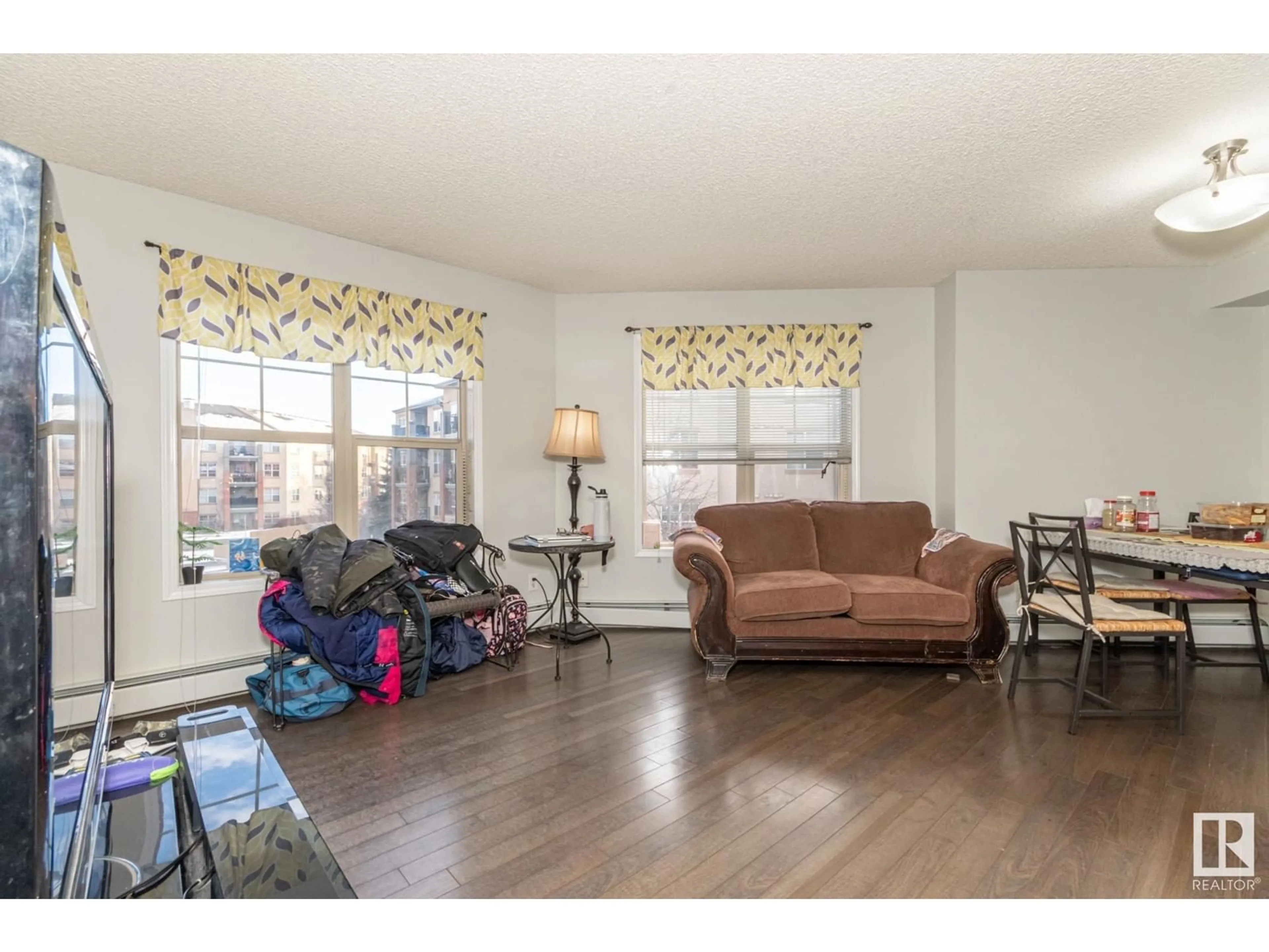 Living room with furniture, wood/laminate floor for #A313 11445 Ellerslie Road SW SW, Edmonton Alberta T6W1T1