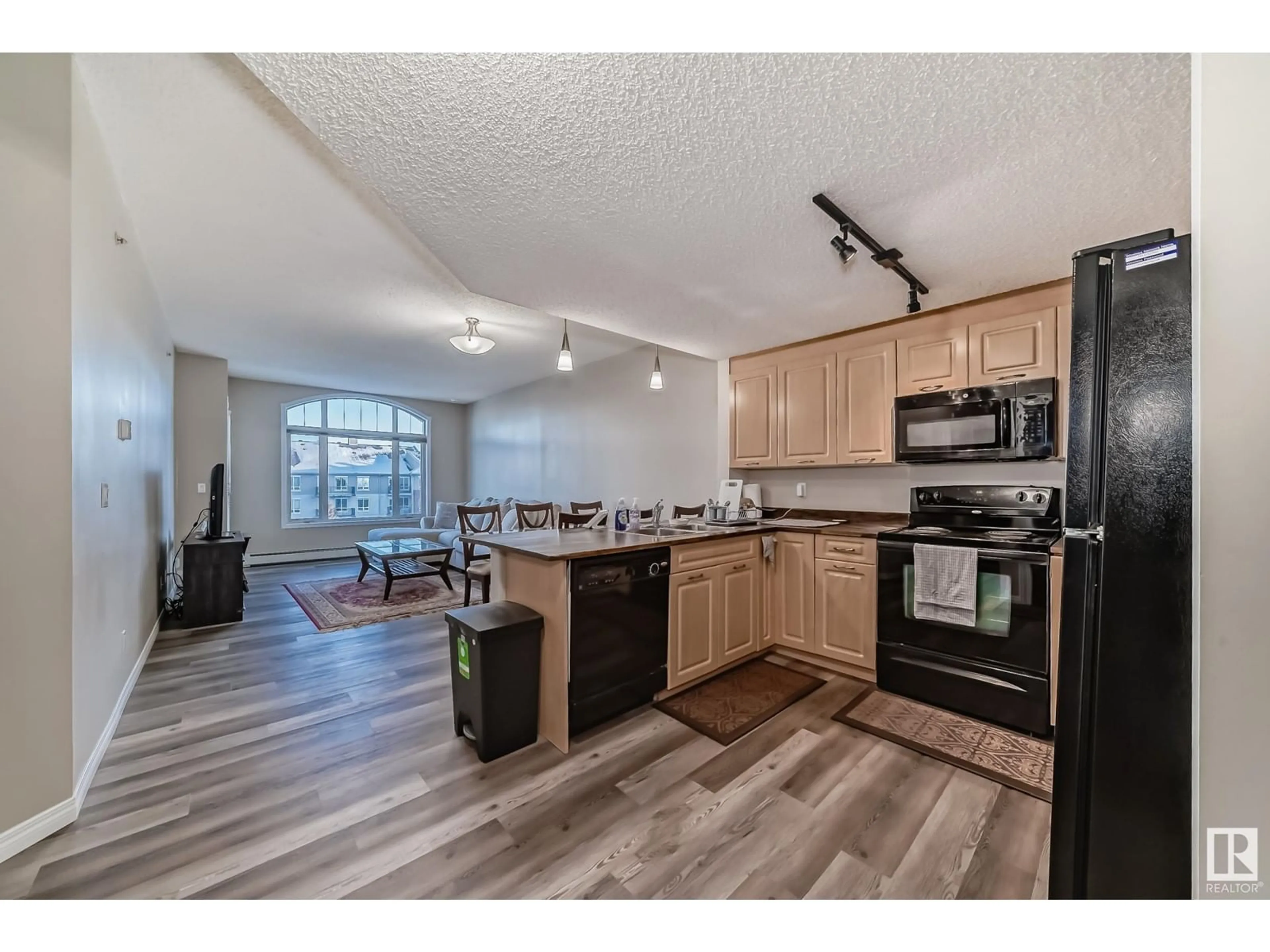 Open concept kitchen, wood/laminate floor for #409 6315 135 AV NW, Edmonton Alberta T5A5J7