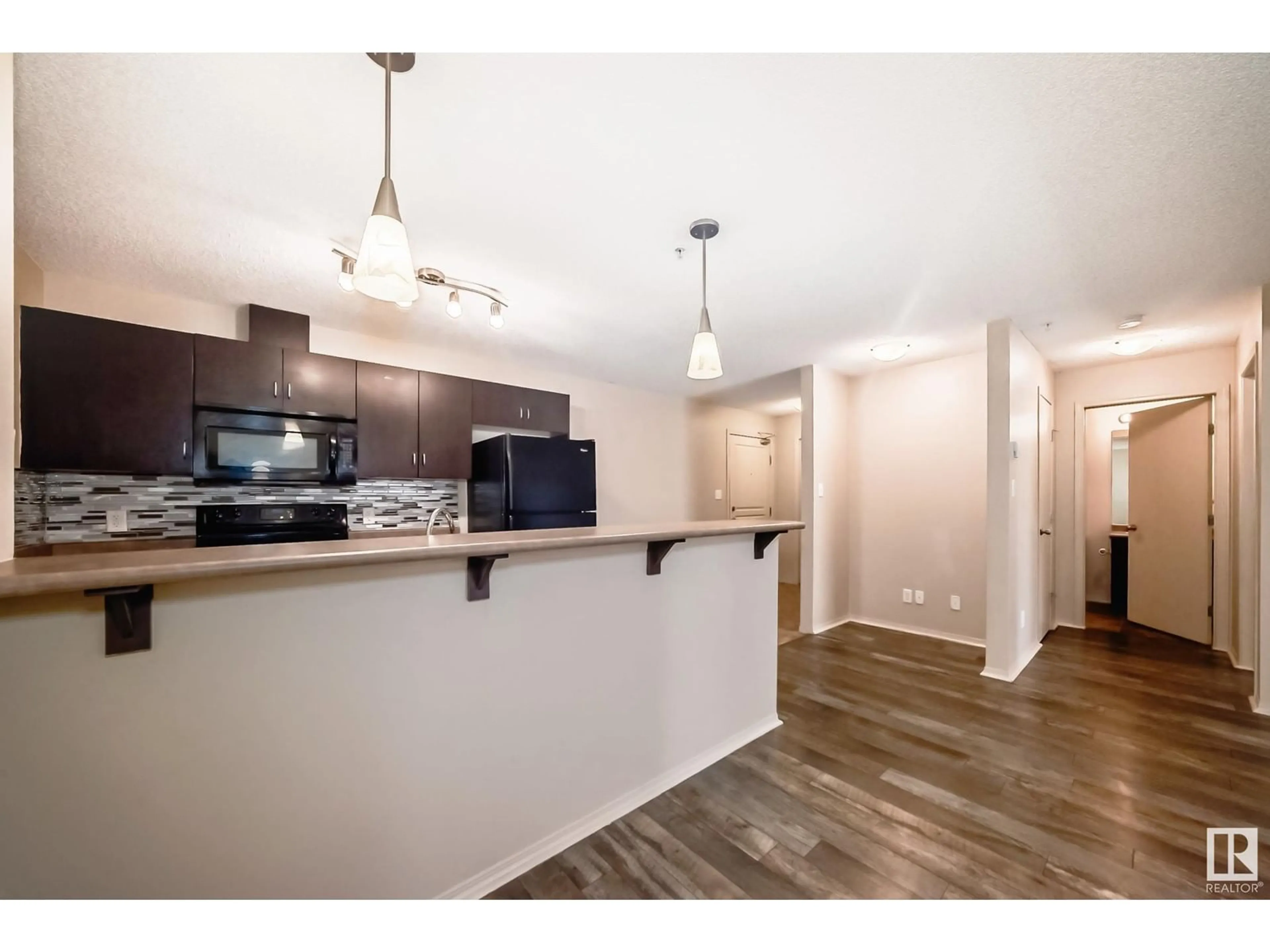 Open concept kitchen, wood/laminate floor for #328 1180 HYNDMAN RD NW, Edmonton Alberta T5A4S9