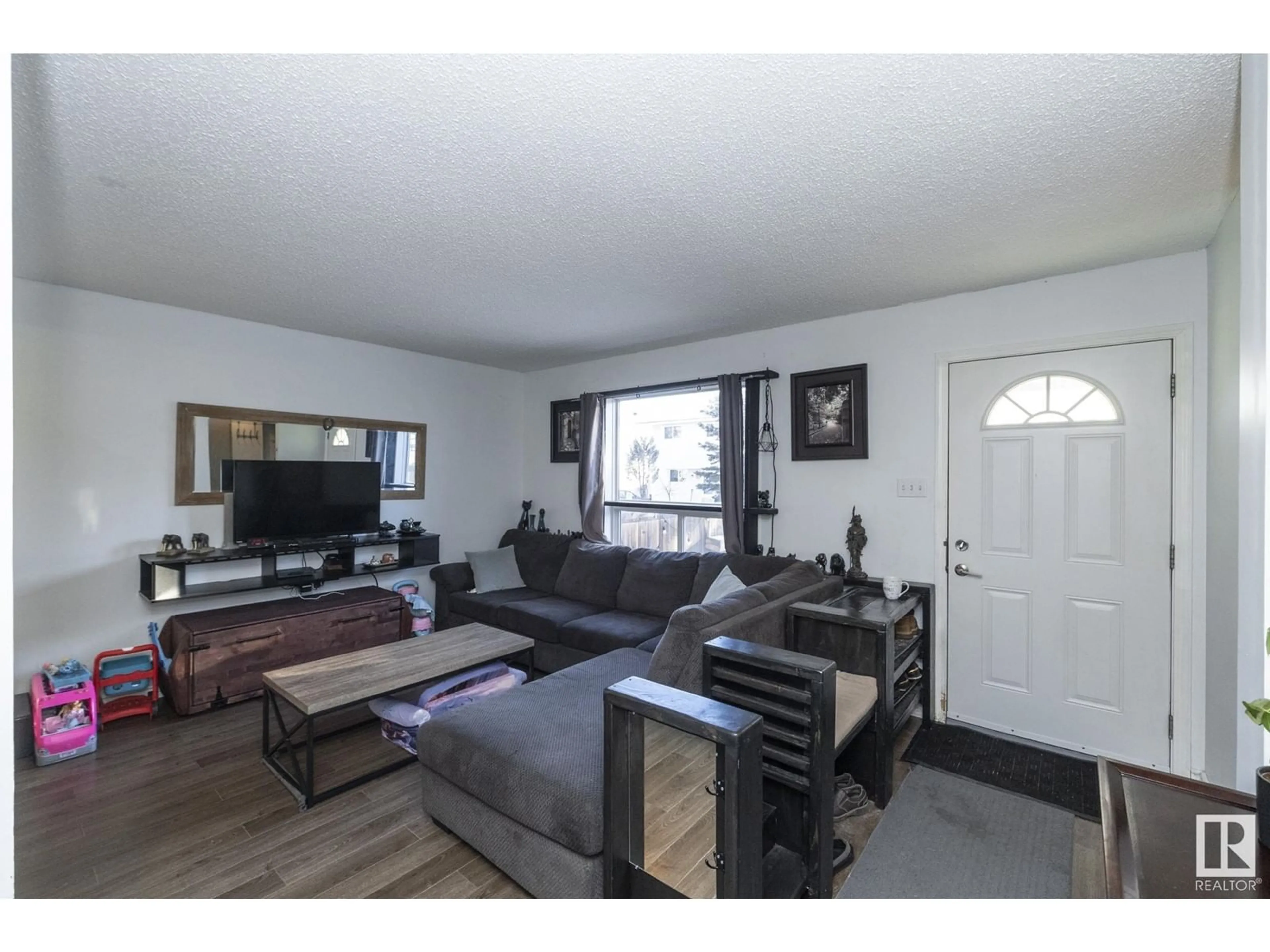 Living room with furniture, wood/laminate floor for 18285 74 AV NW, Edmonton Alberta T5T2G6