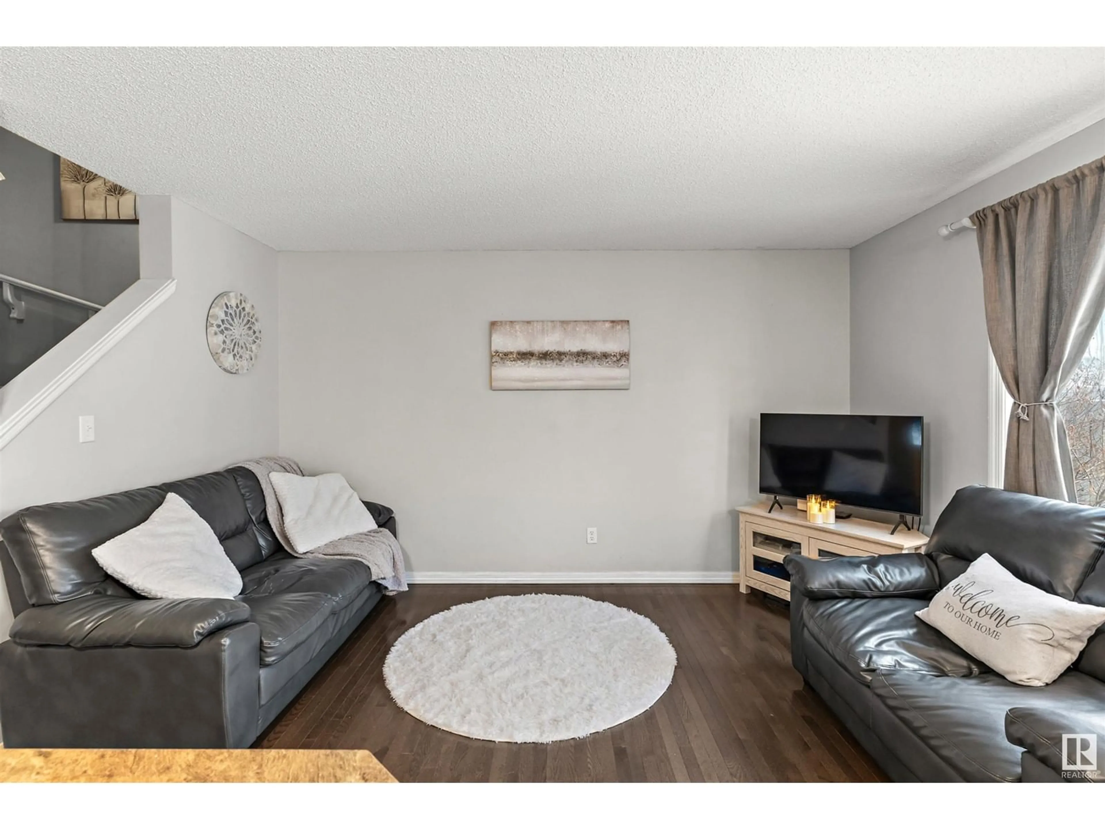 Living room with furniture, wood/laminate floor for 138 CALVERT WD, Fort Saskatchewan Alberta T8L0E6