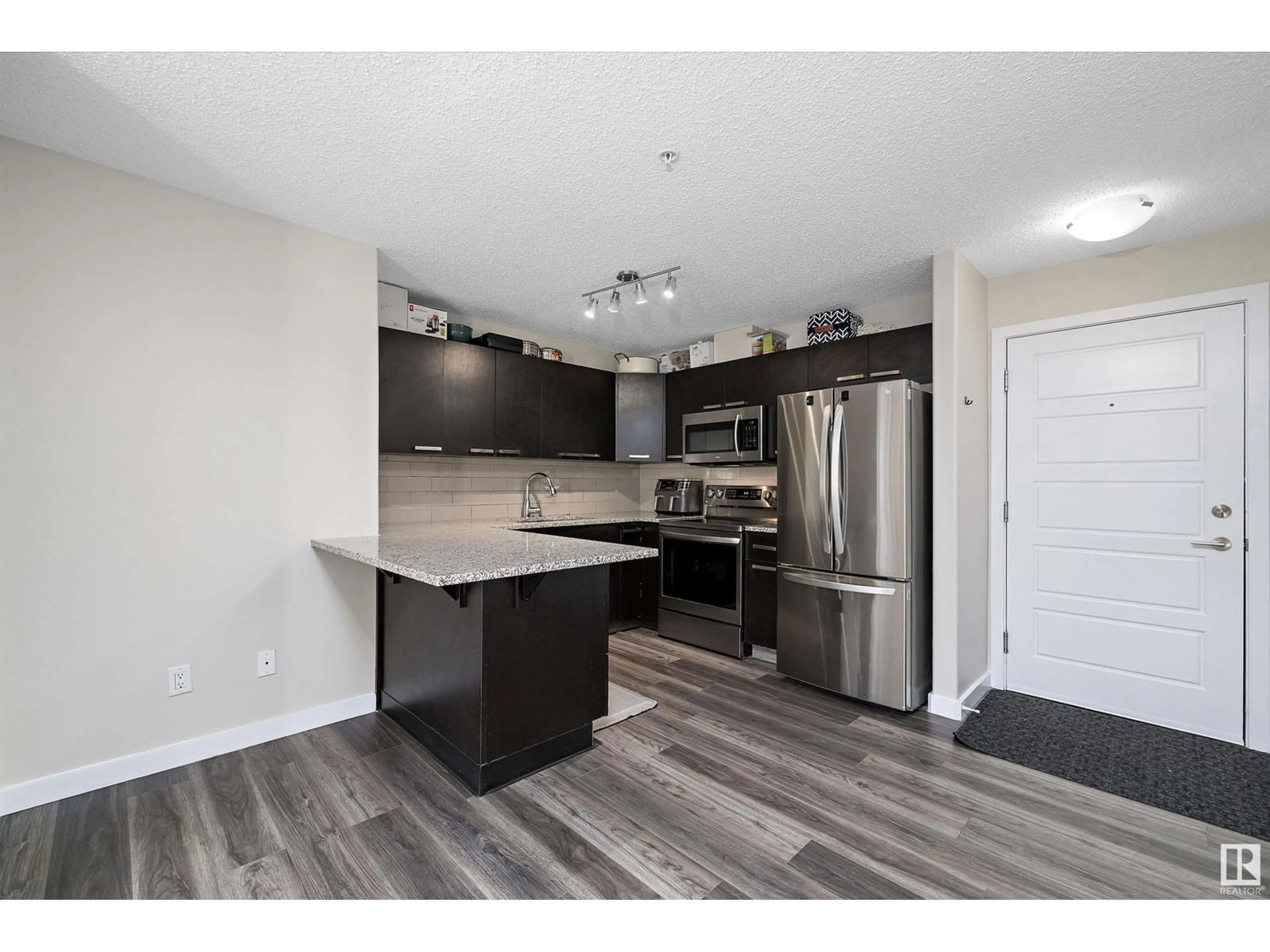 Open concept kitchen, wood/laminate floor for #109 14808 125 ST NW, Edmonton Alberta T5X0G1