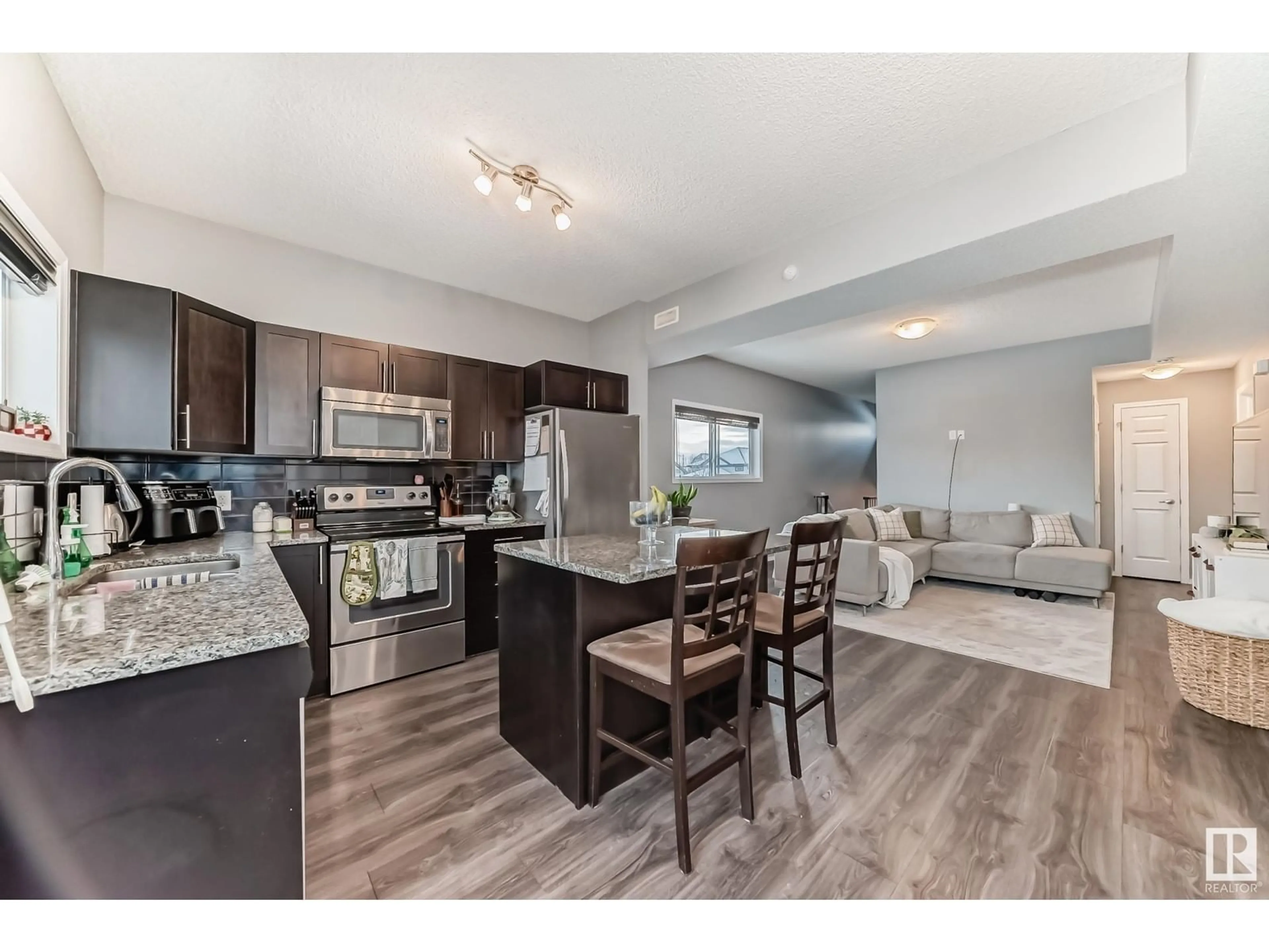 Open concept kitchen, wood/laminate floor for #33 6520 2 AV SW, Edmonton Alberta T6X1S4