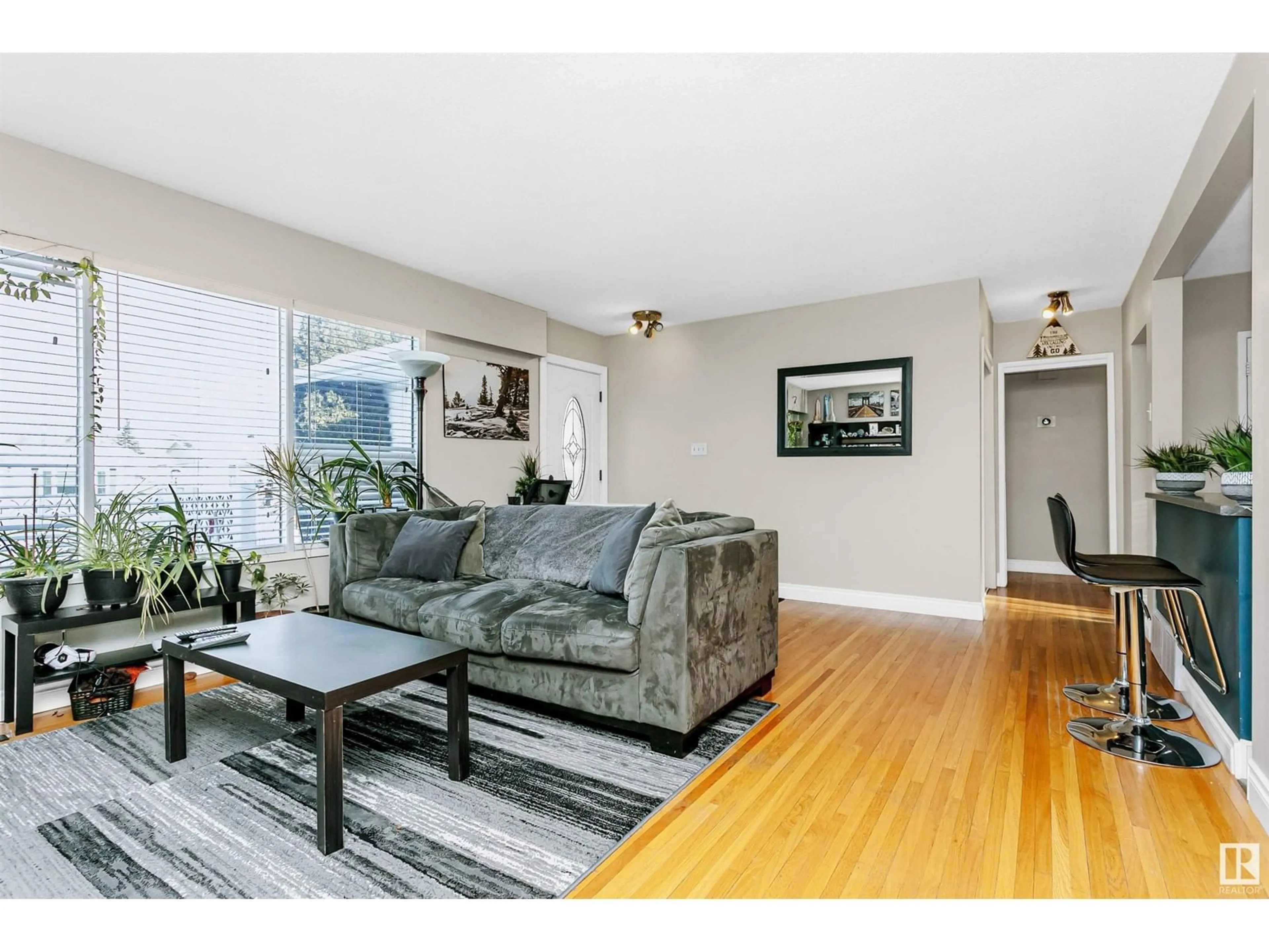 Living room with furniture, wood/laminate floor for 7027 138 AV NW, Edmonton Alberta T5C2L9