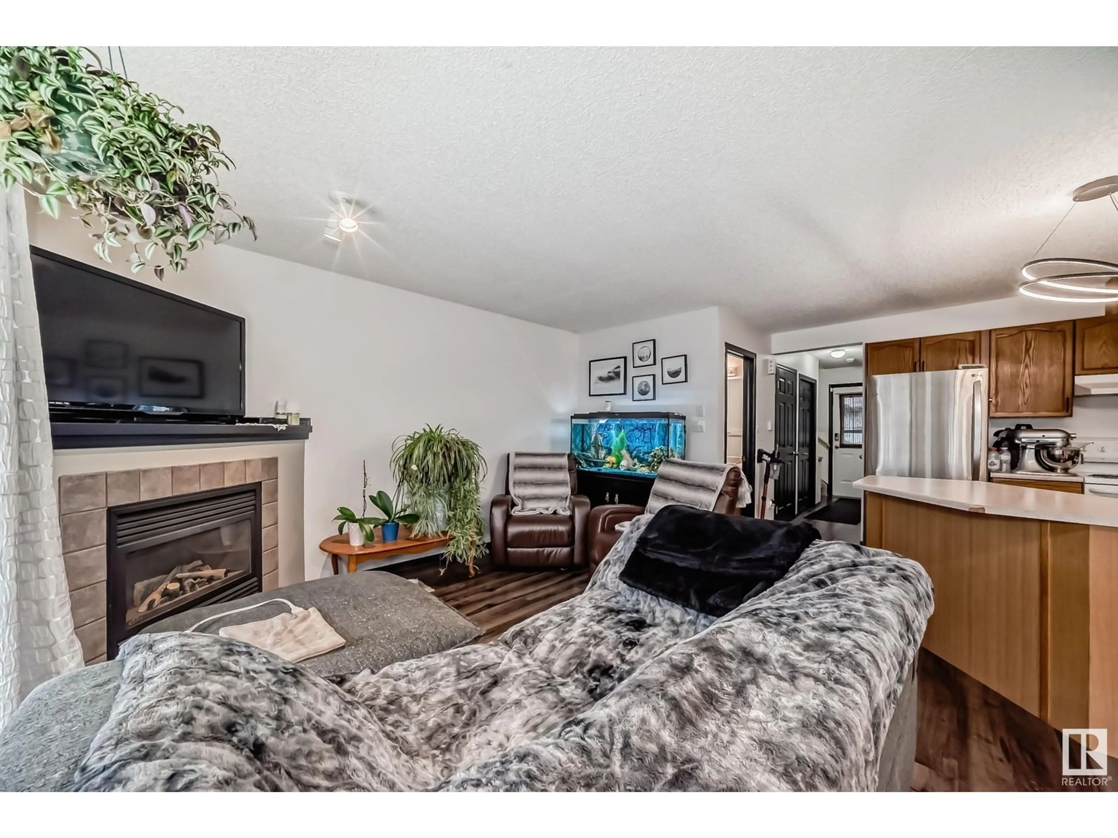 Living room with furniture, wood/laminate floor for #7 14803 Miller BV NW, Edmonton Alberta T5Y3A4