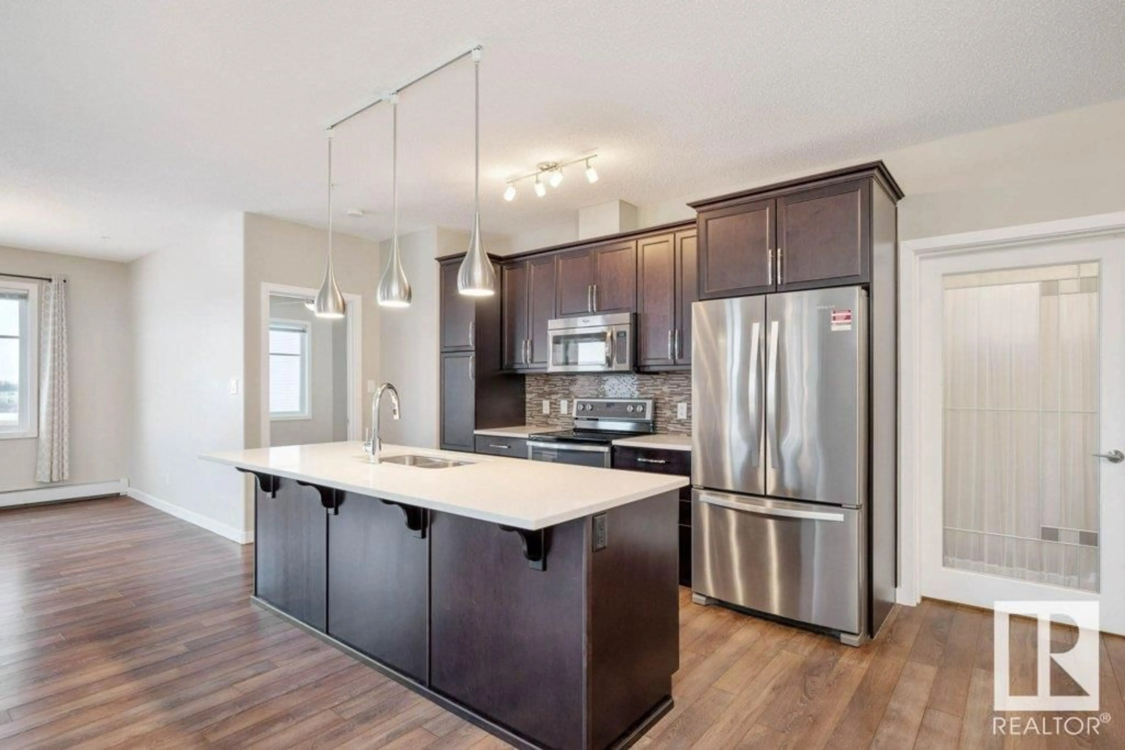 Open concept kitchen, wood/laminate floor for #336 503 ALBANY WY NW, Edmonton Alberta T6V0M5