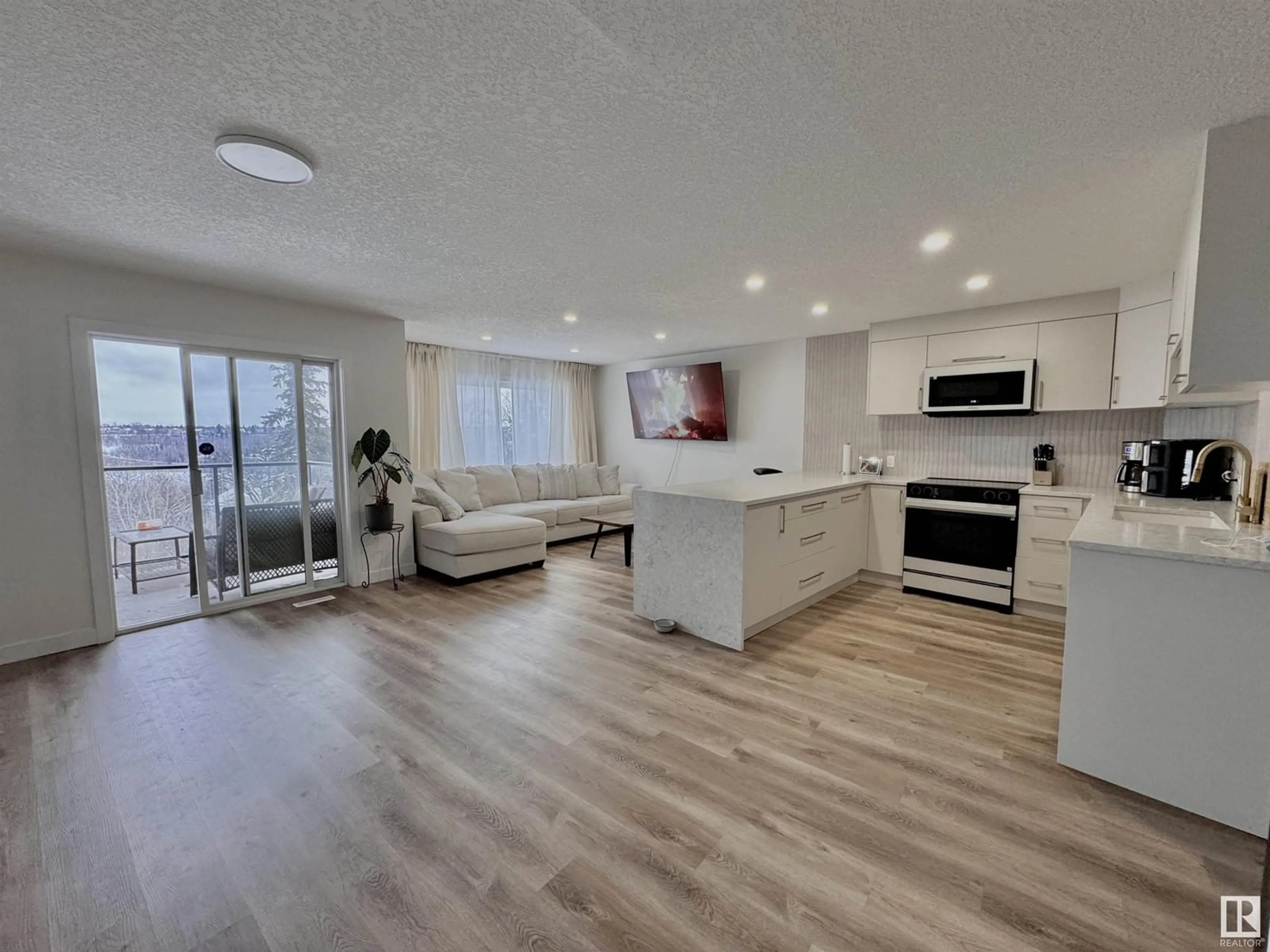 Open concept kitchen, wood/laminate floor for #108 10105 95 ST NW, Edmonton Alberta T5H4M4