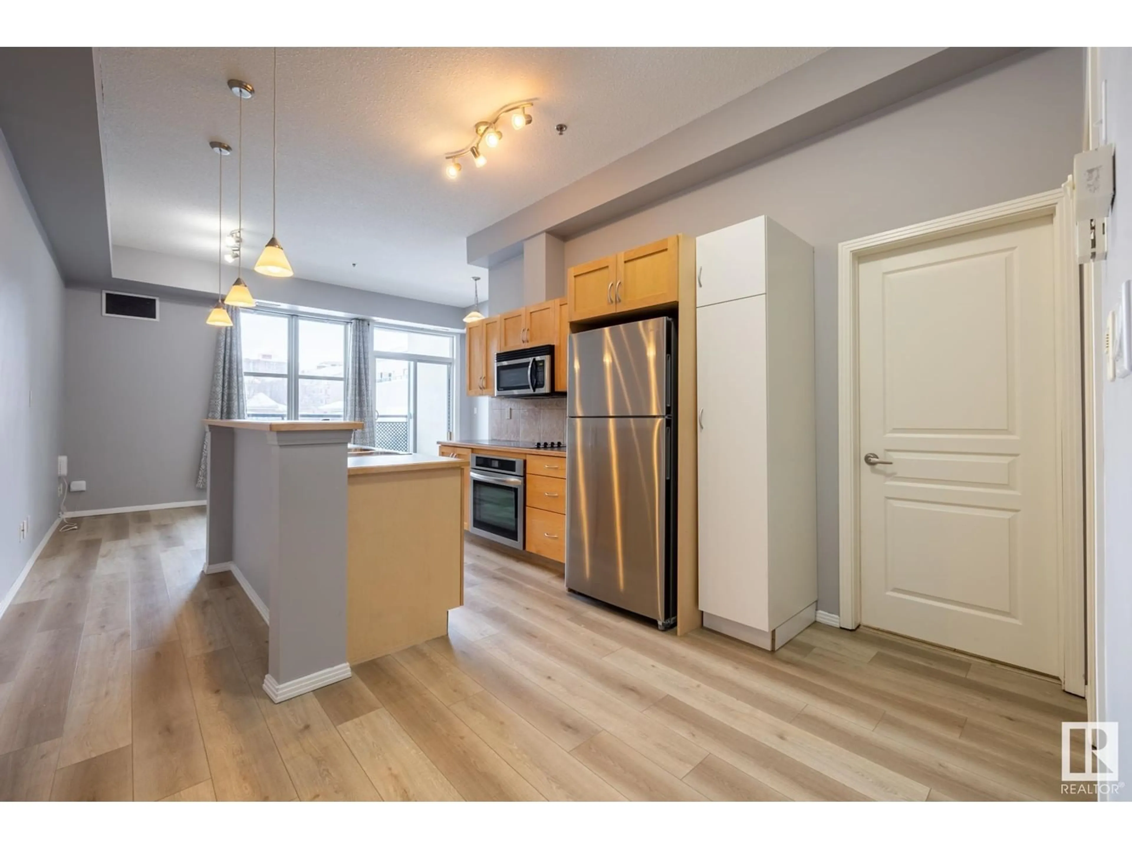 Open concept kitchen, wood/laminate floor for #210 10147 112 ST NW, Edmonton Alberta T5K1M1