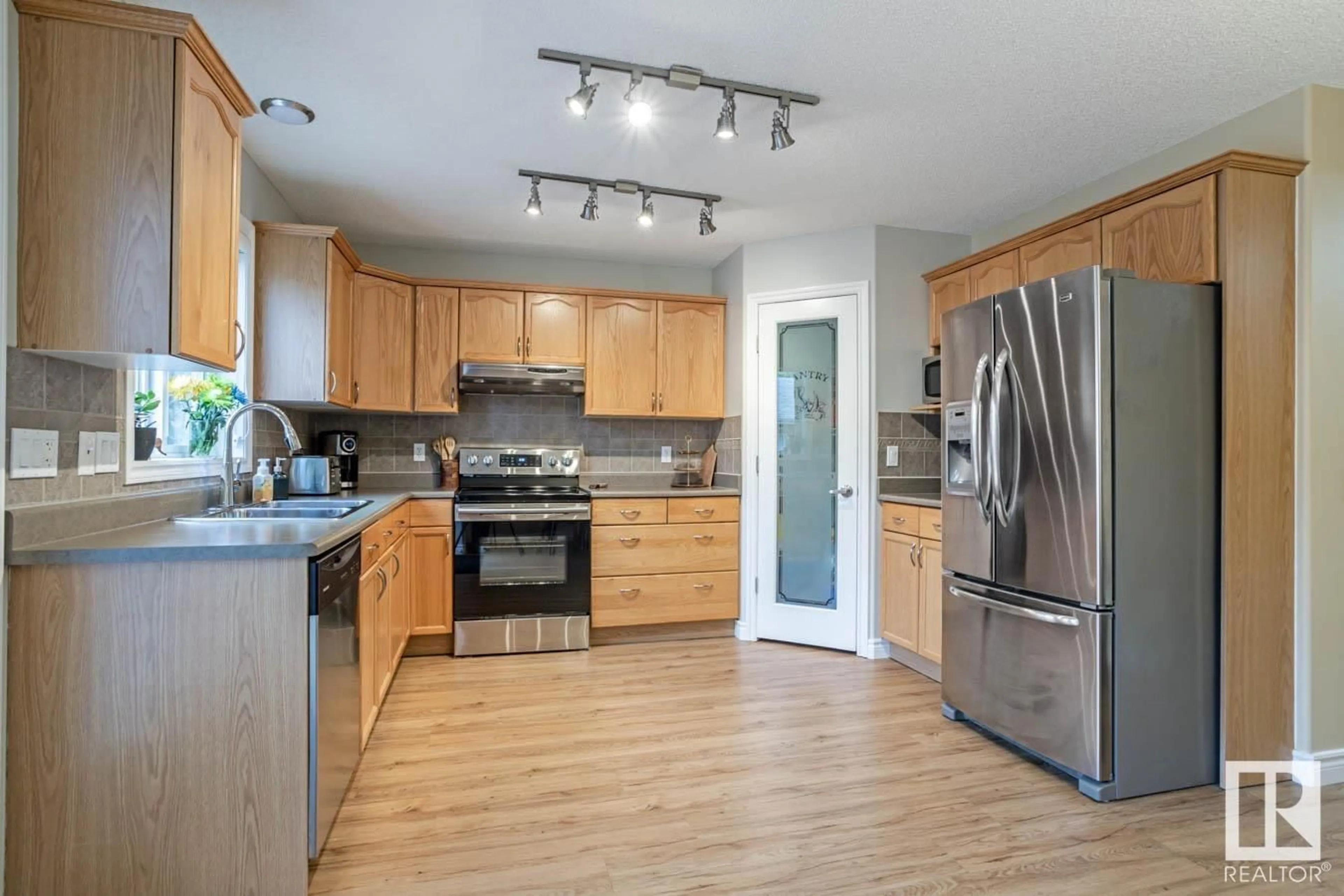 Open concept kitchen, wood/laminate floor for 7545 80 AV NW, Edmonton Alberta T6C0S3