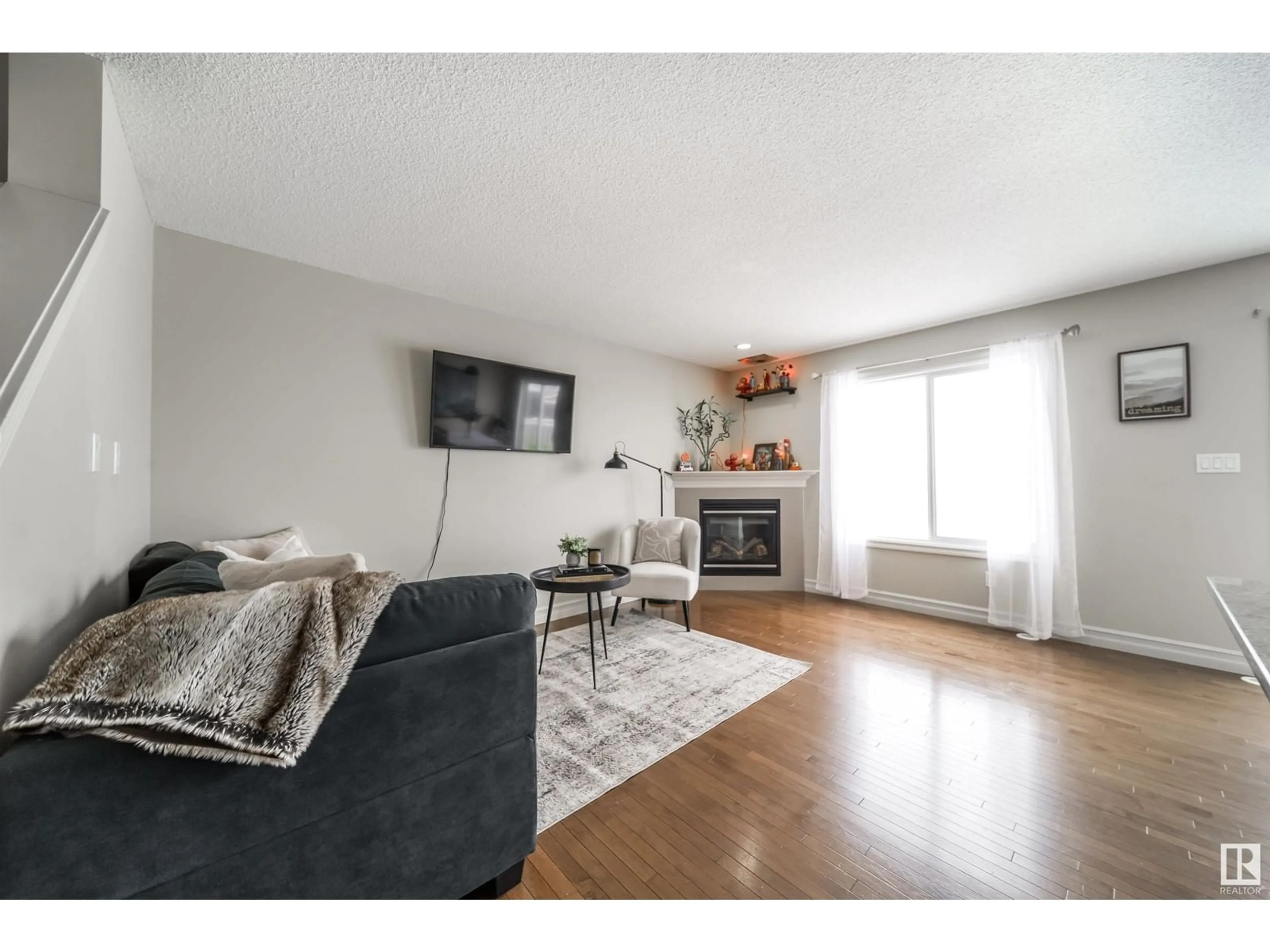 Living room with furniture, wood/laminate floor for 16112 10 AV SW, Edmonton Alberta T6W2G9