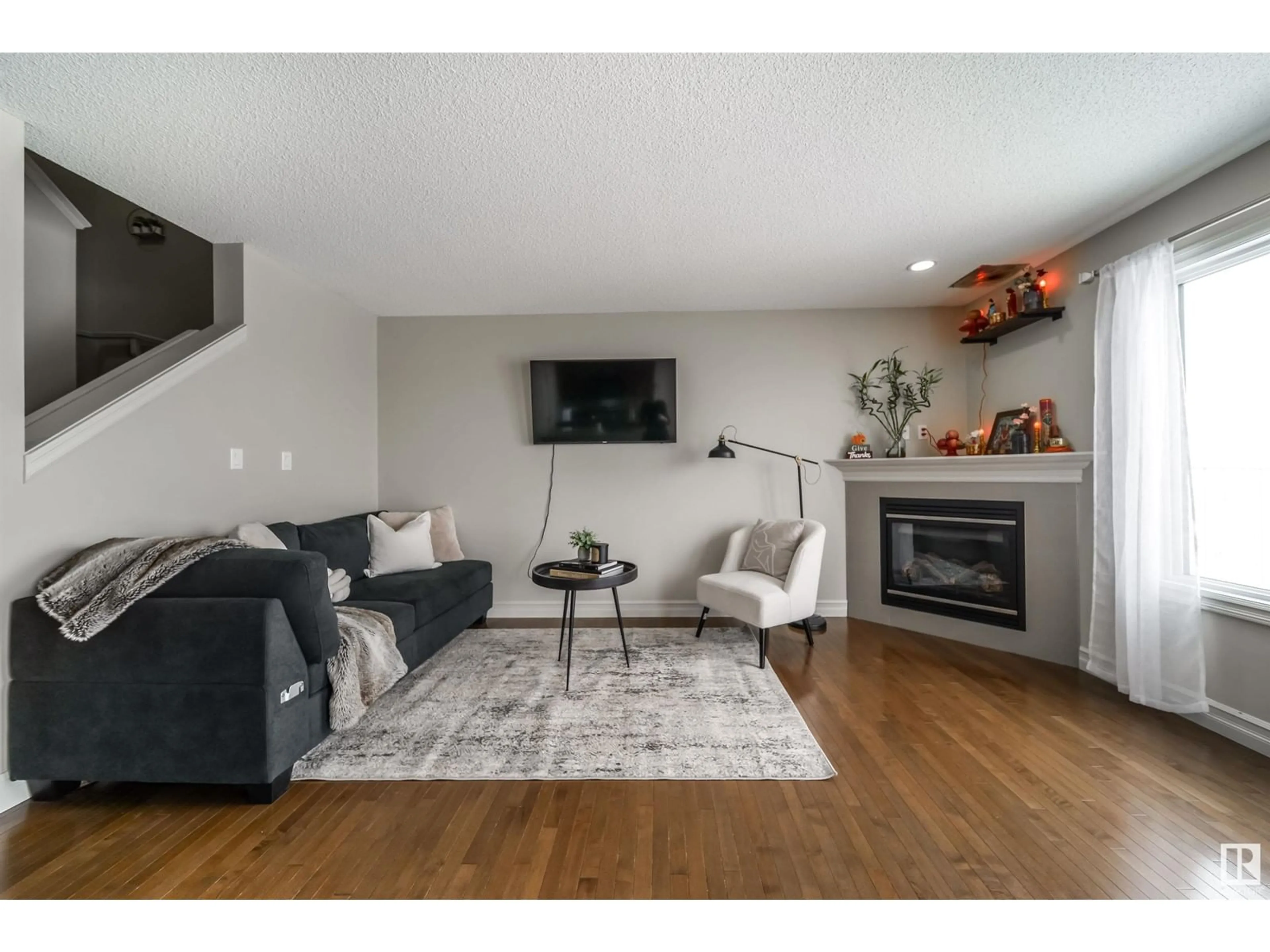 Living room with furniture, wood/laminate floor for 16112 10 AV SW, Edmonton Alberta T6W2G9