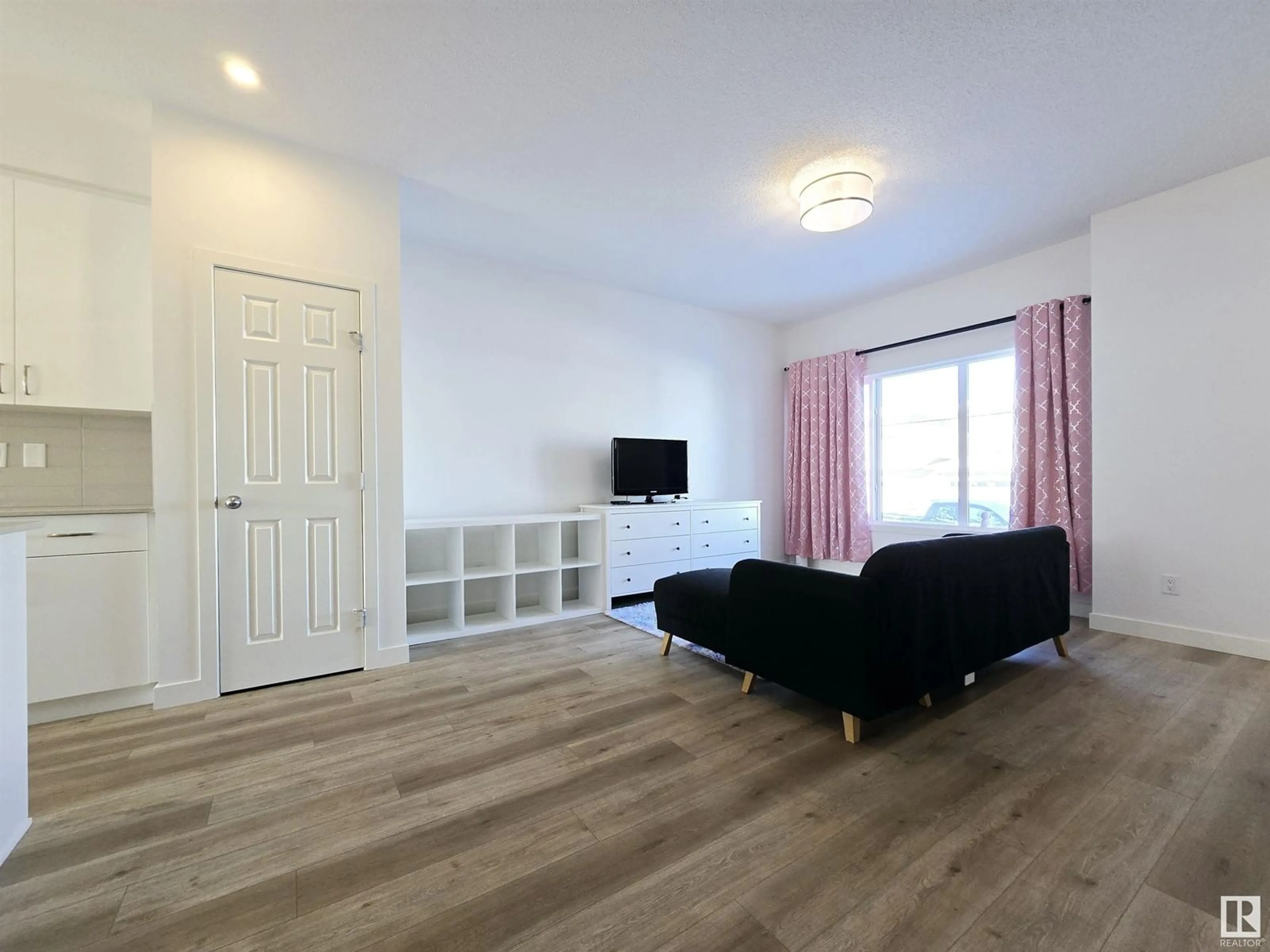 Living room with furniture, wood/laminate floor for 15651 18 AV SW, Edmonton Alberta T6W5C2