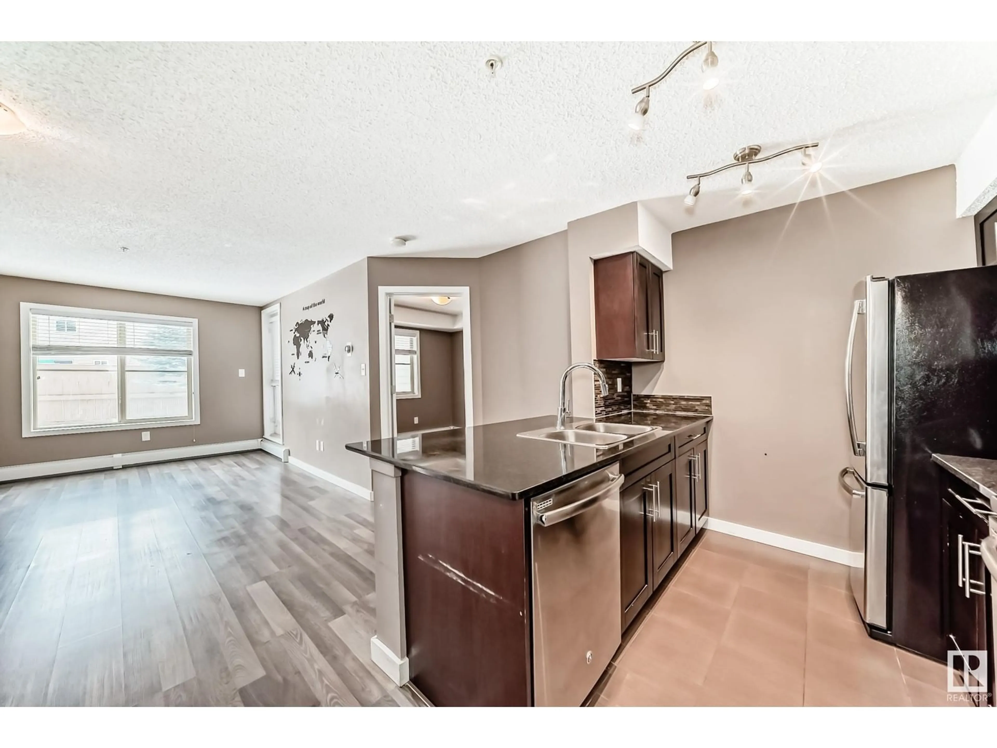 Open concept kitchen, wood/laminate floor for #114 1060 MCCONACHIE BV NW, Edmonton Alberta T5Y0W9