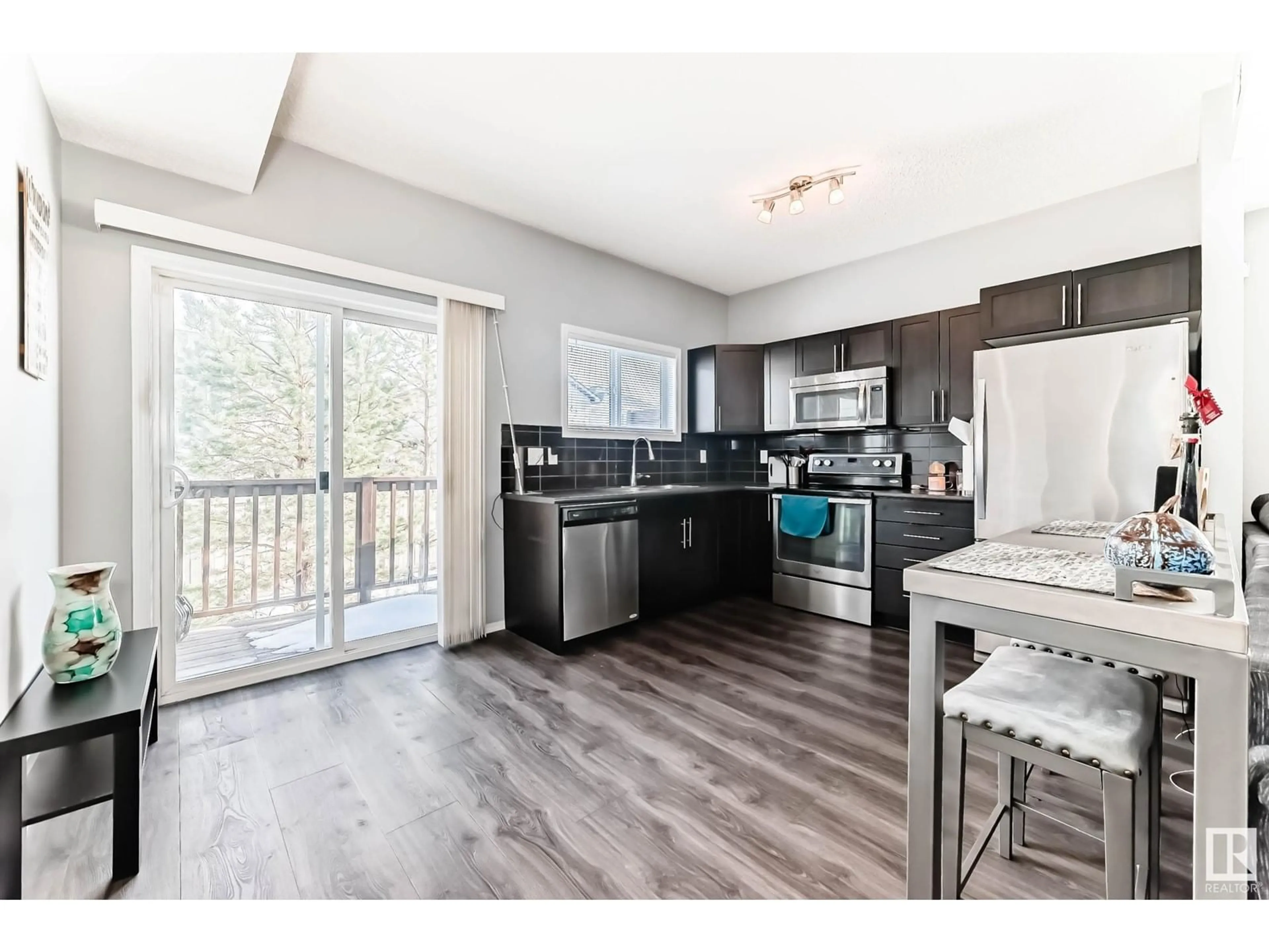 Open concept kitchen, wood/laminate floor for #9 6520 2 AV SW, Edmonton Alberta T6X1S4