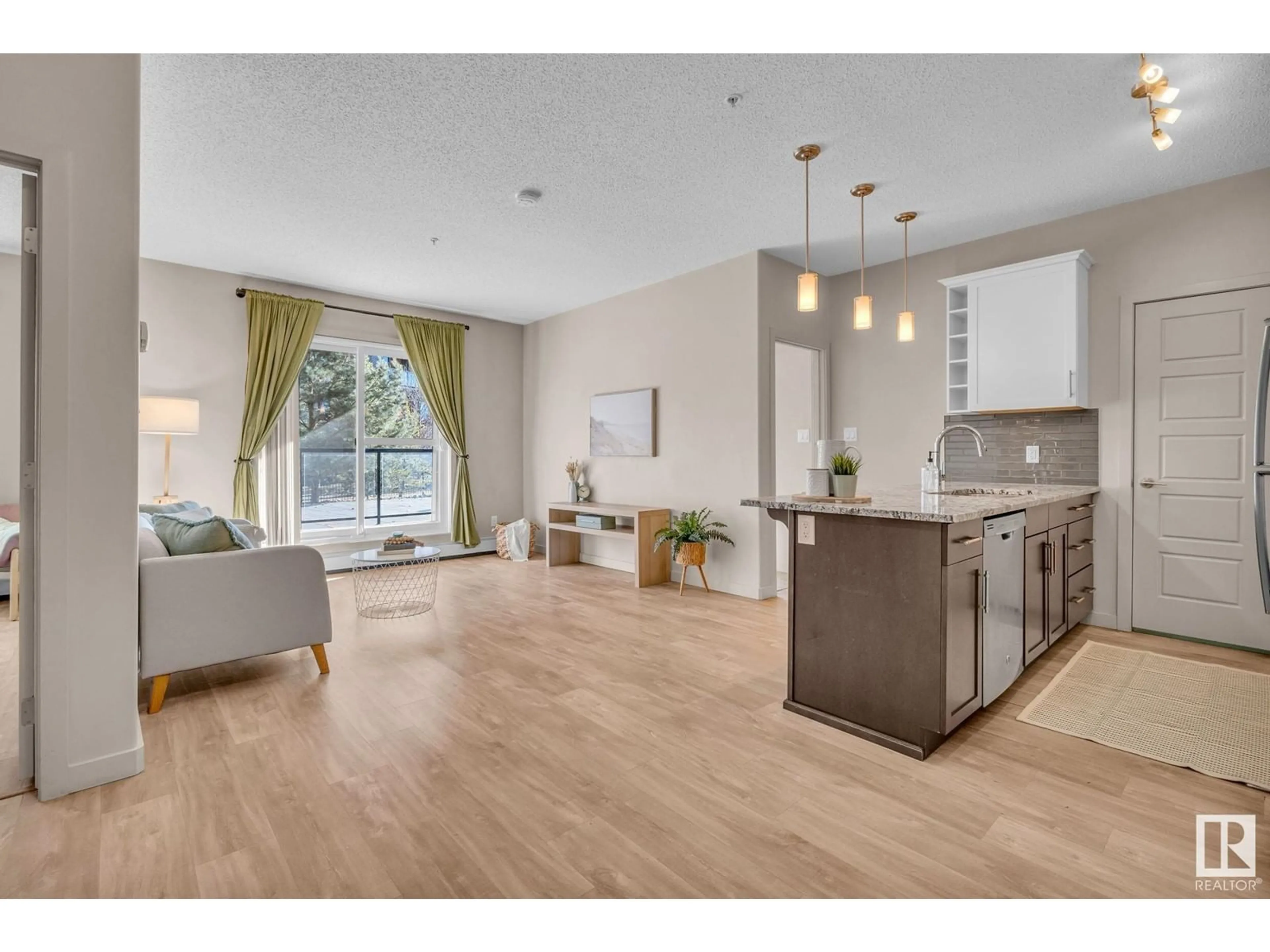 Open concept kitchen, wood/laminate floor for #105 320 AMBLESIDE LINK LI SW, Edmonton Alberta T6W2Z9