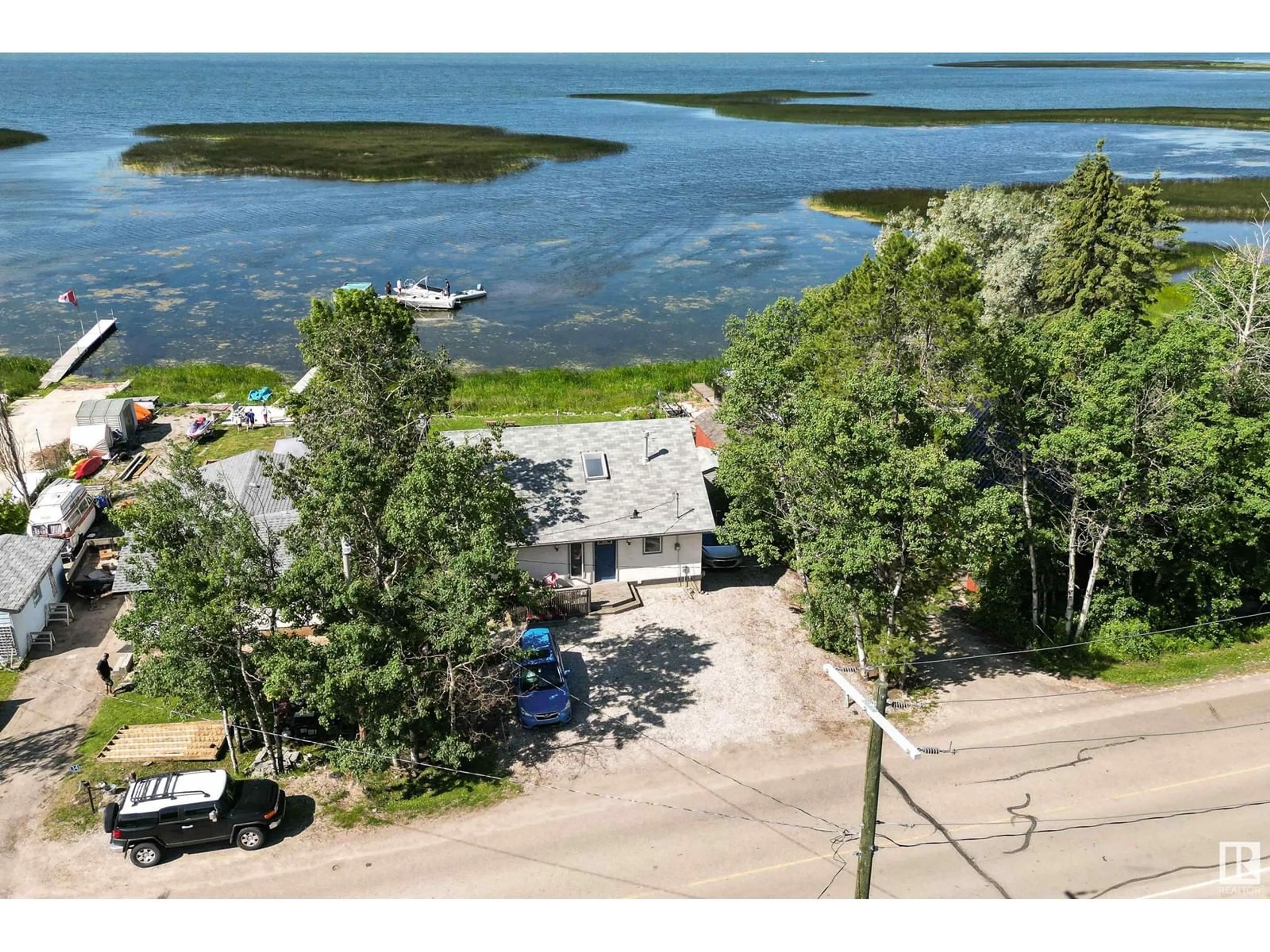 A pic from outside/outdoor area/front of a property/back of a property/a pic from drone, water/lake/river/ocean view for #36 55022 STE. ANNE TR, Rural Lac Ste. Anne County Alberta T0E0A1