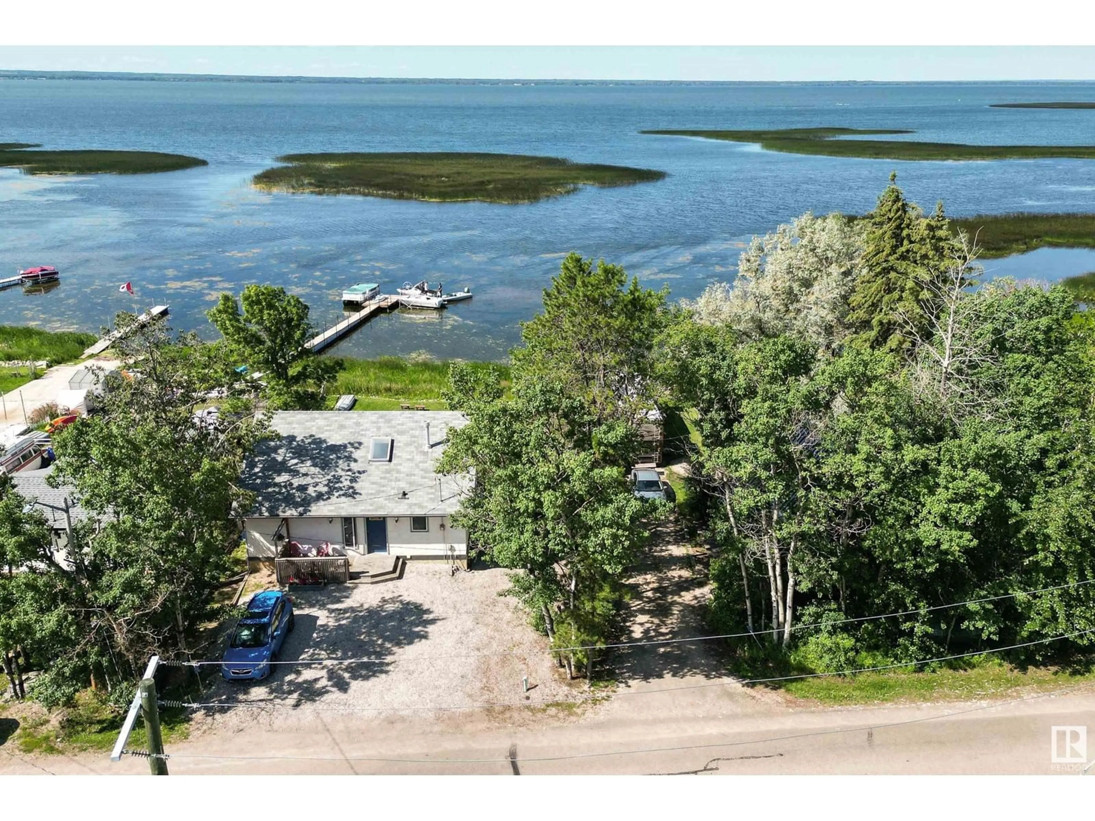 A pic from outside/outdoor area/front of a property/back of a property/a pic from drone, water/lake/river/ocean view for #36 55022 STE. ANNE TR, Rural Lac Ste. Anne County Alberta T0E0A1