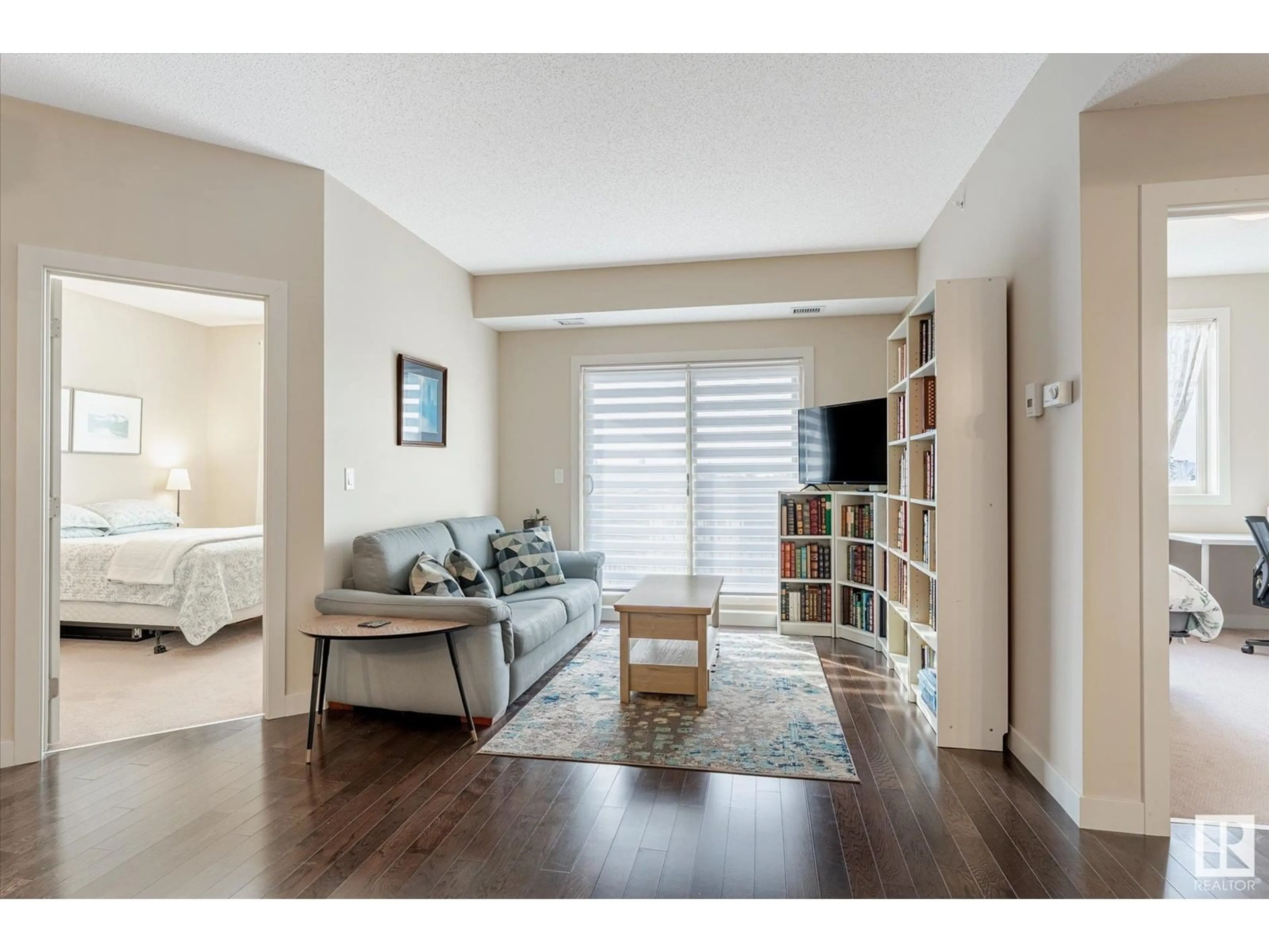 Living room with furniture, wood/laminate floor for #418 10520 56 AV NW, Edmonton Alberta T6H0X7