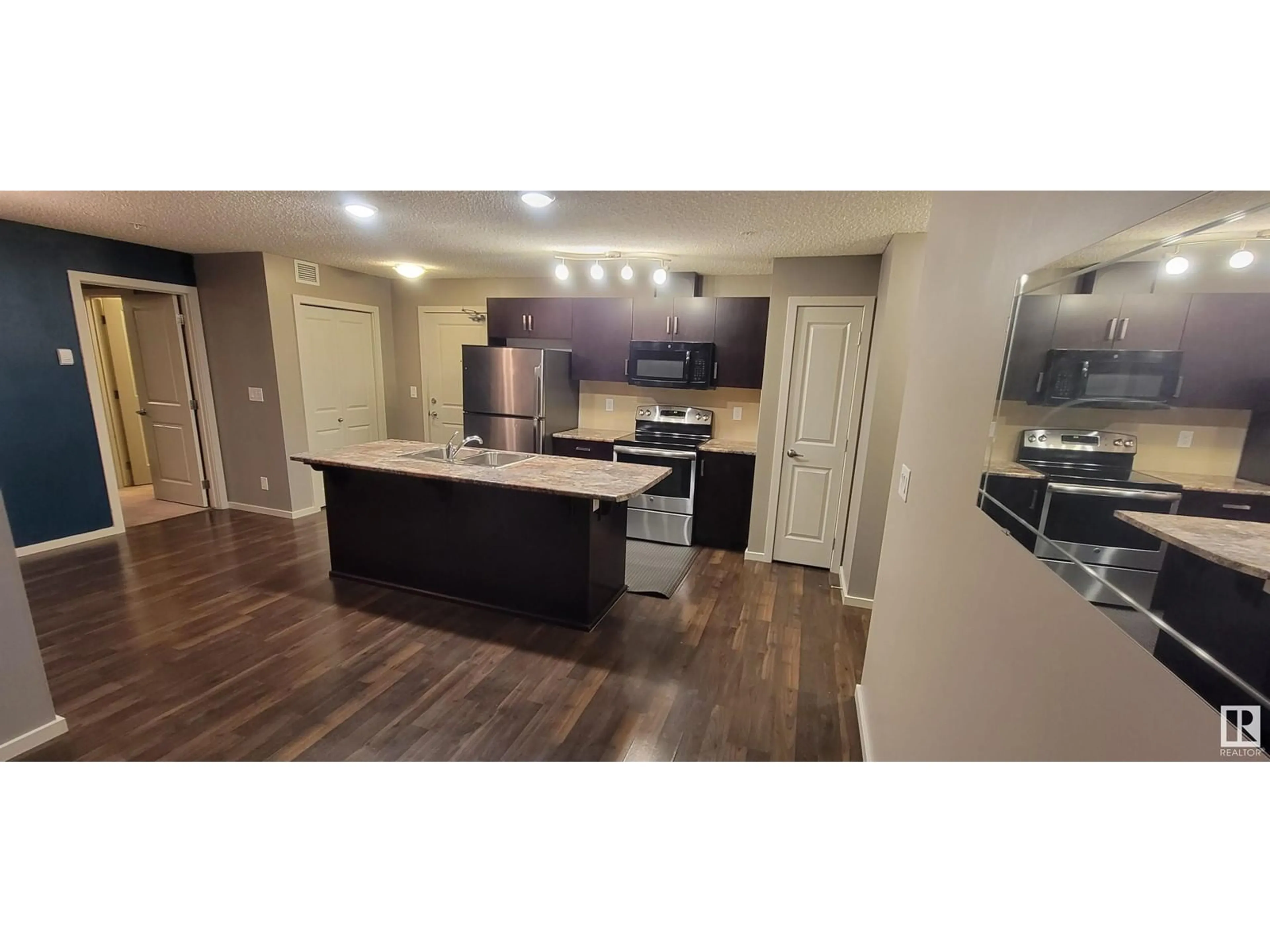 Open concept kitchen, wood/laminate floor for #115 5521 7 AV SW SW, Edmonton Alberta T6X2A8