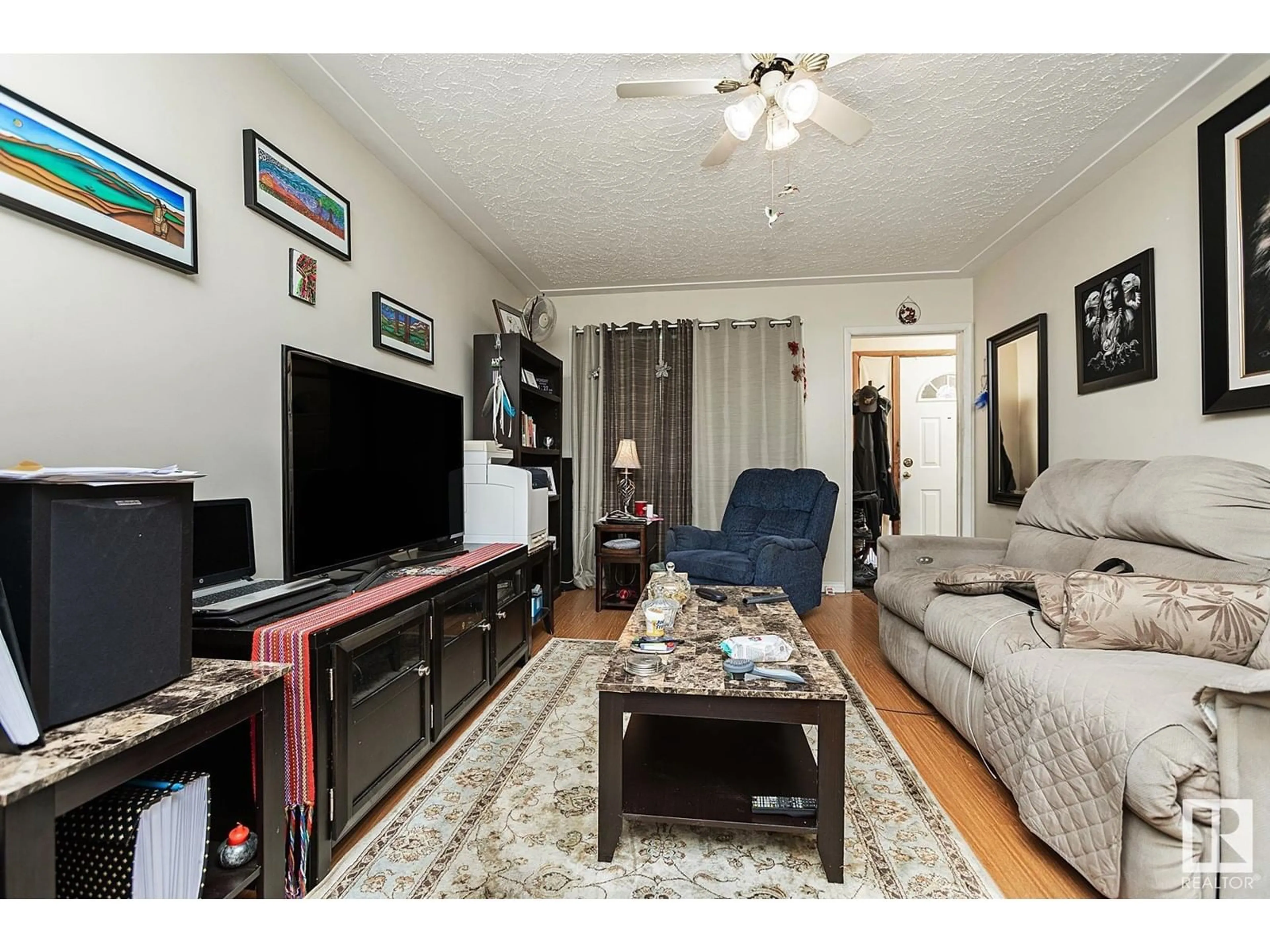 Living room with furniture, wood/laminate floor for 10939 98 ST NW, Edmonton Alberta T5H2P7