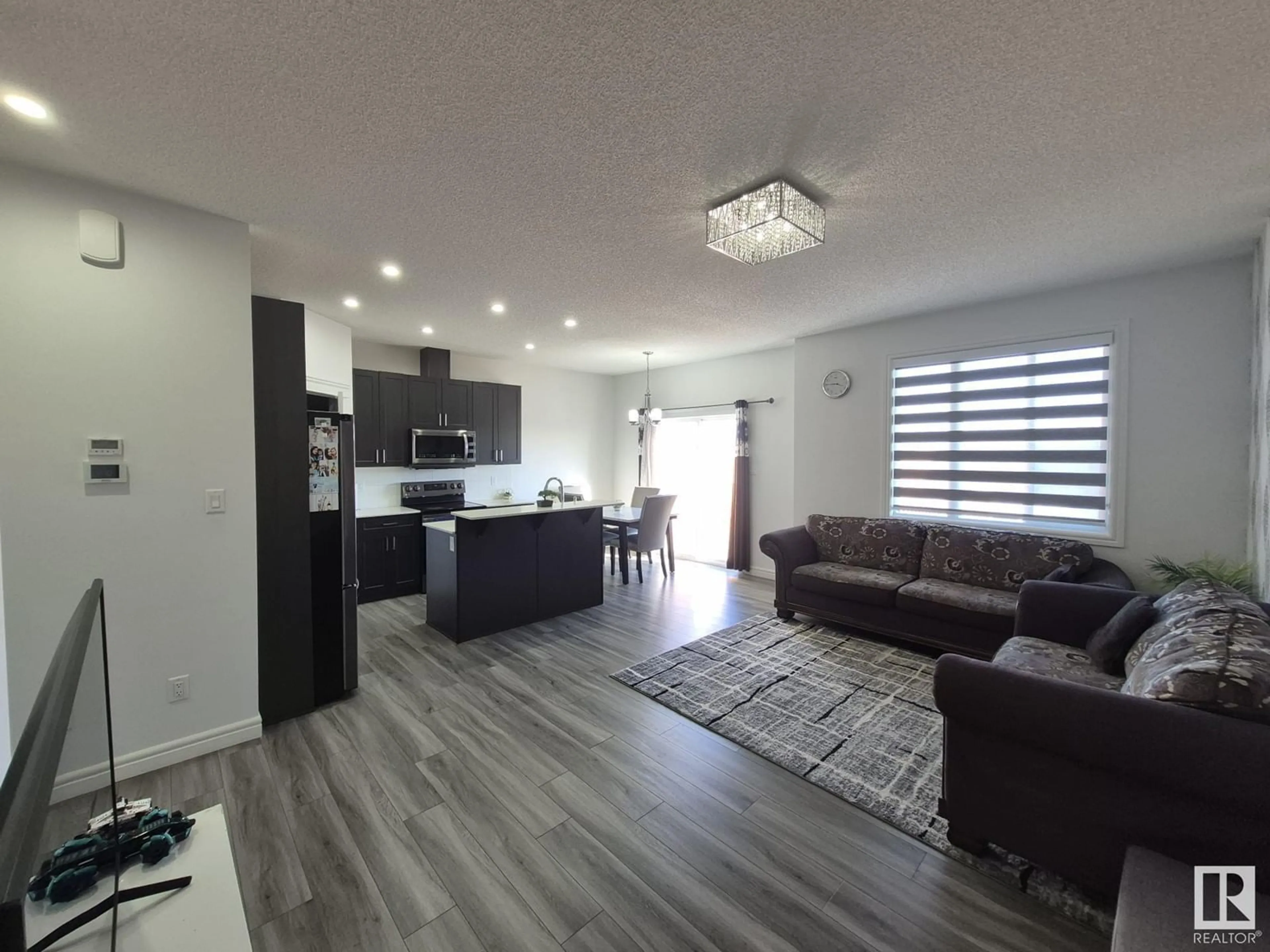 Living room with furniture, wood/laminate floor for 2523 12 AV NW, Edmonton Alberta T6T2M6