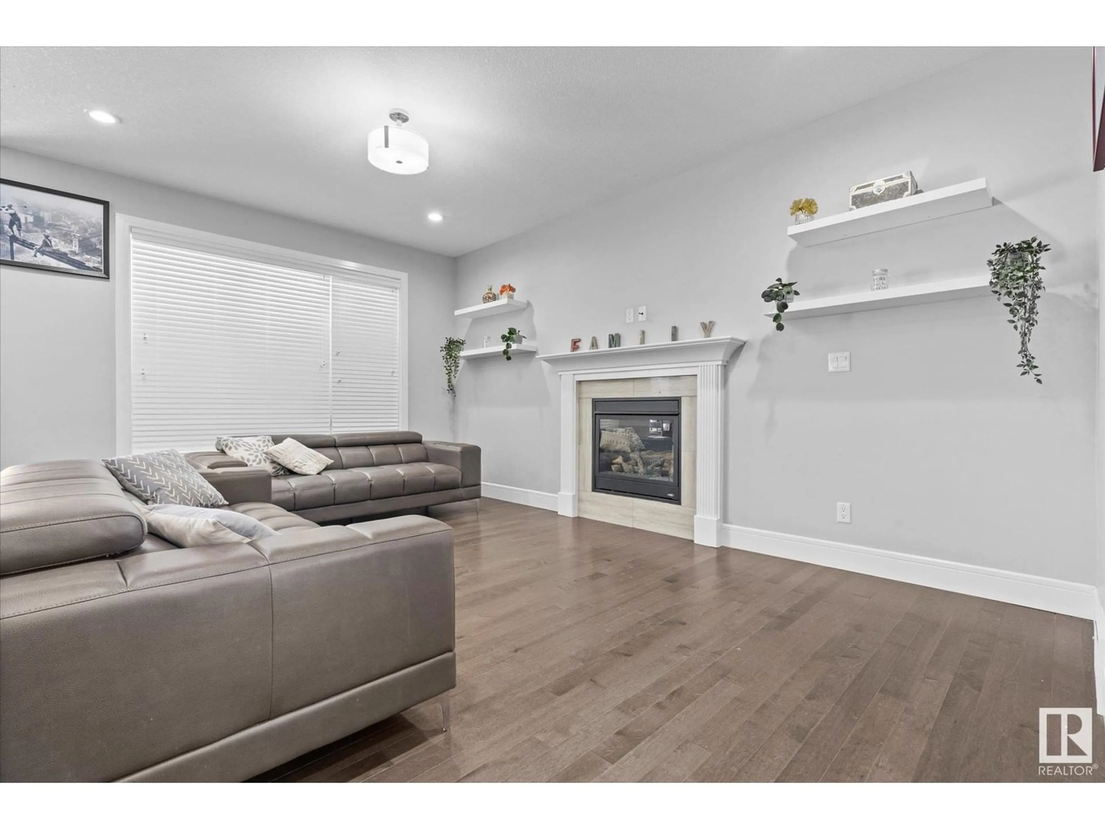Living room with furniture, wood/laminate floor for 189 WOODHILL LN, Fort Saskatchewan Alberta T8L0L5