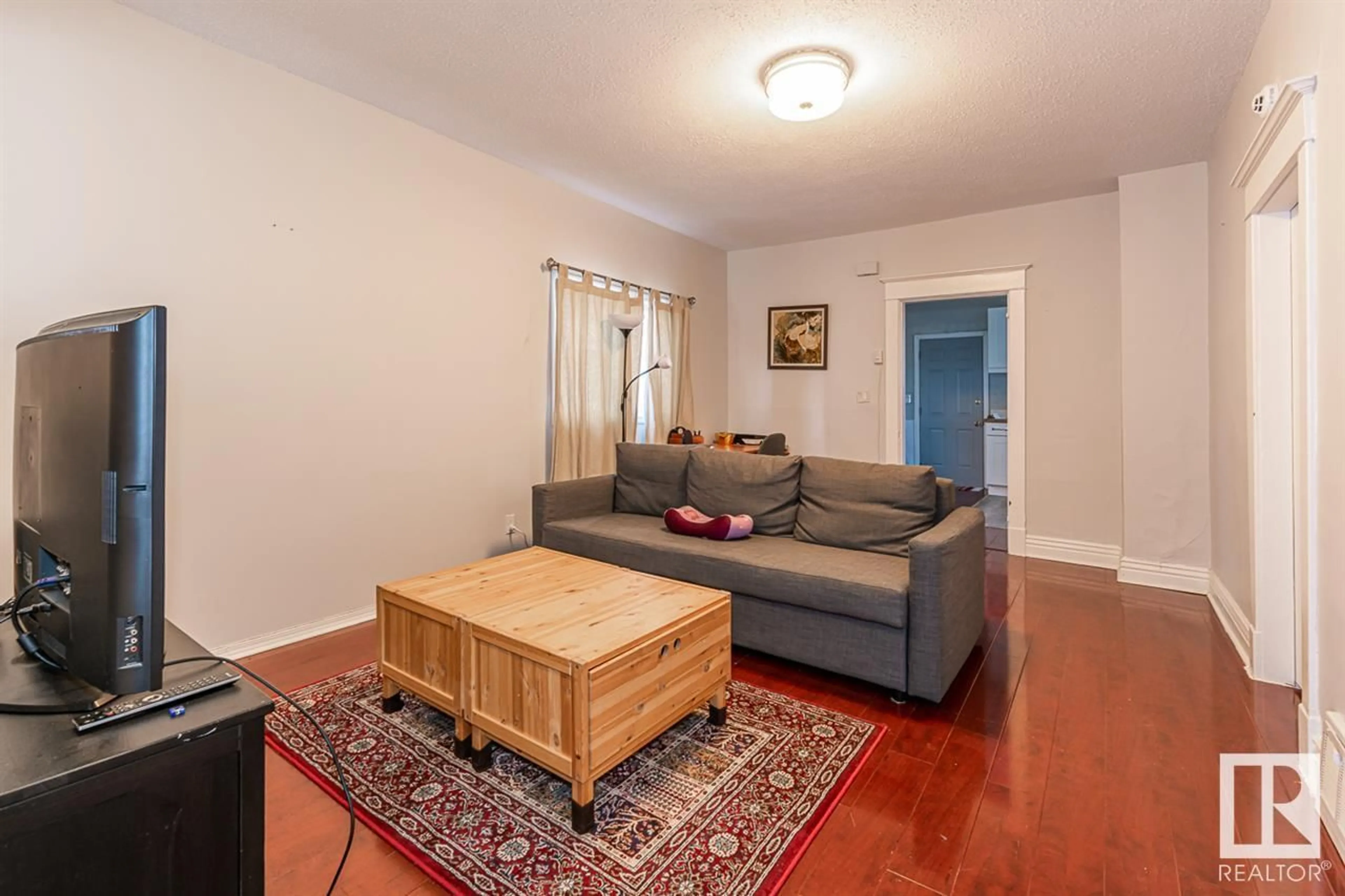 Living room with furniture, wood/laminate floor for 9332 106A AV, Edmonton Alberta T5H0S7