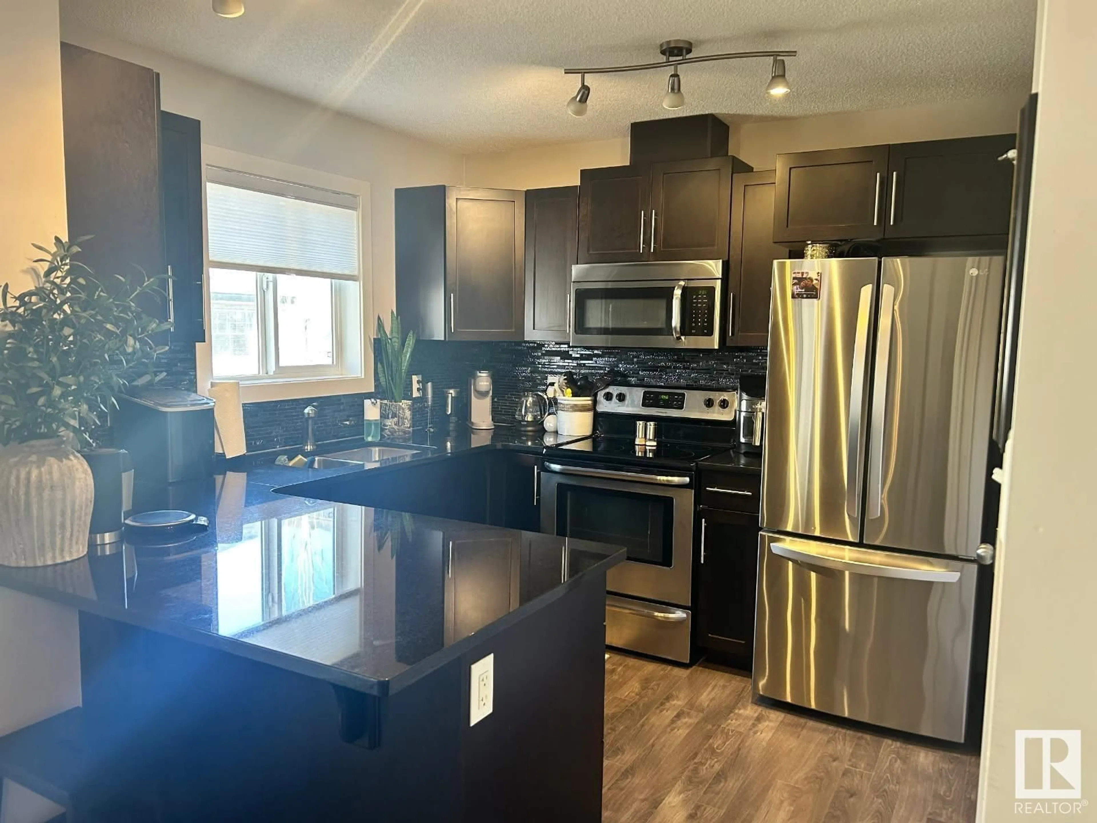 Open concept kitchen, wood/laminate floor for #22 - 12004 22 AV, Edmonton Alberta T6W0T1