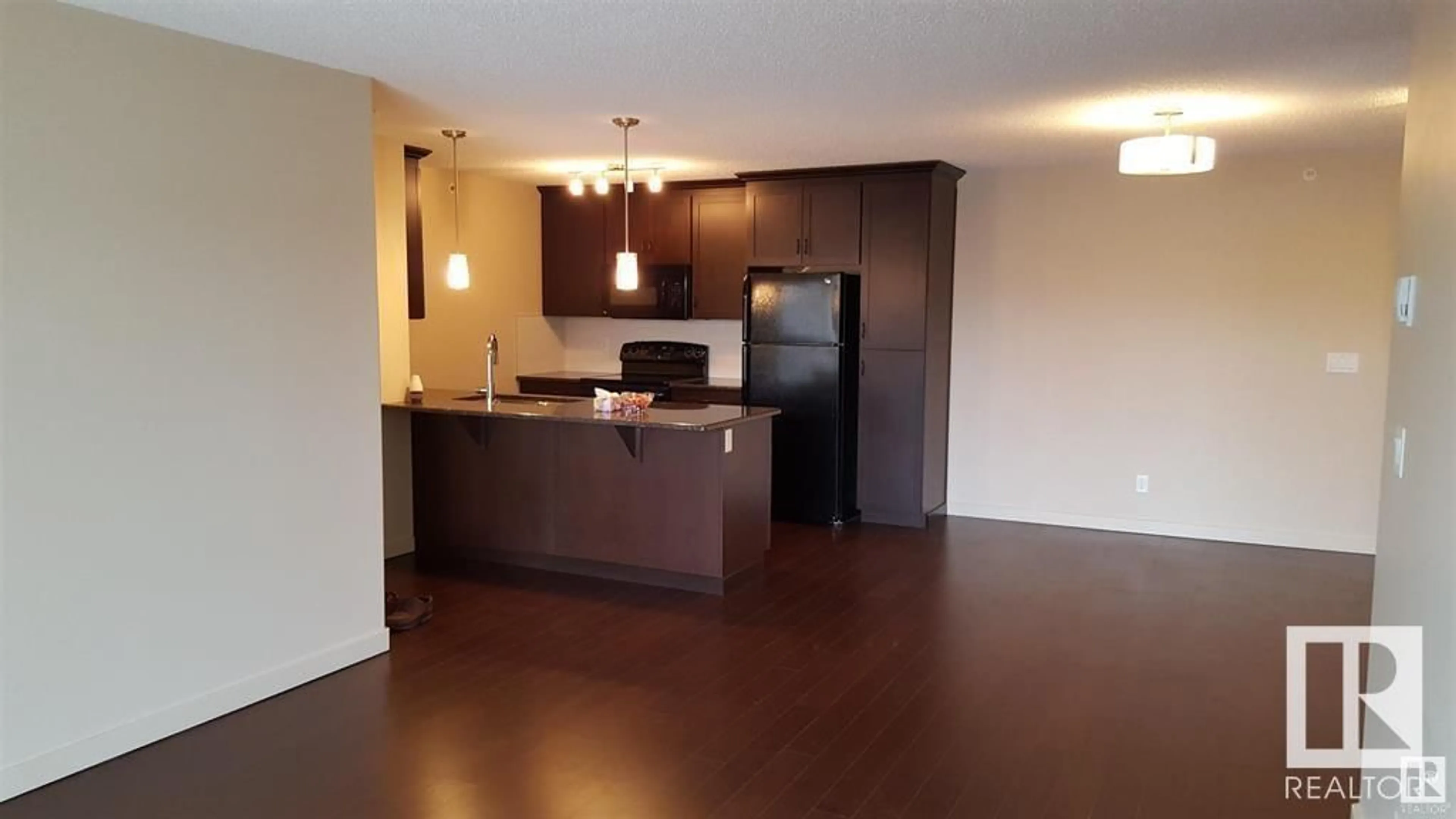 Open concept kitchen, wood/laminate floor for #437 - 6076 SCHONSEE WY, Edmonton Alberta T5Z0K8