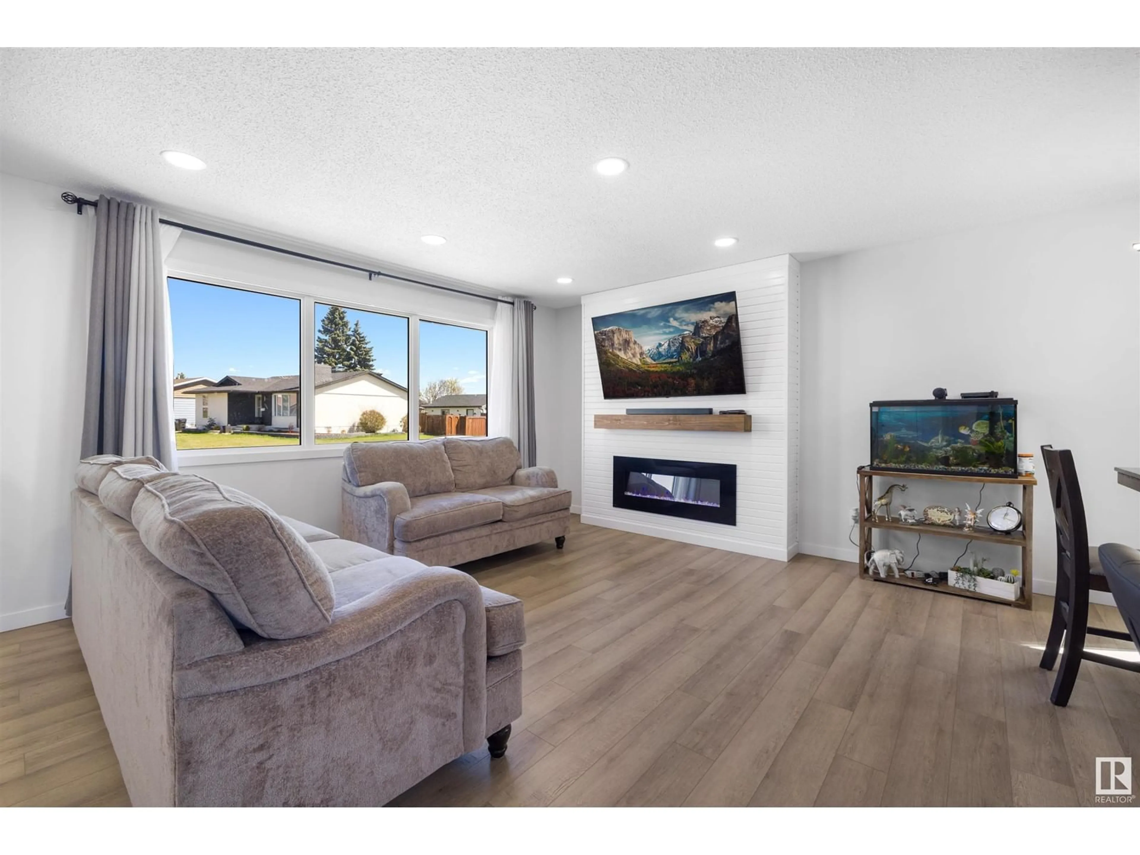 Living room with furniture, wood/laminate floor for 4619 128 AV, Edmonton Alberta T5A2M7