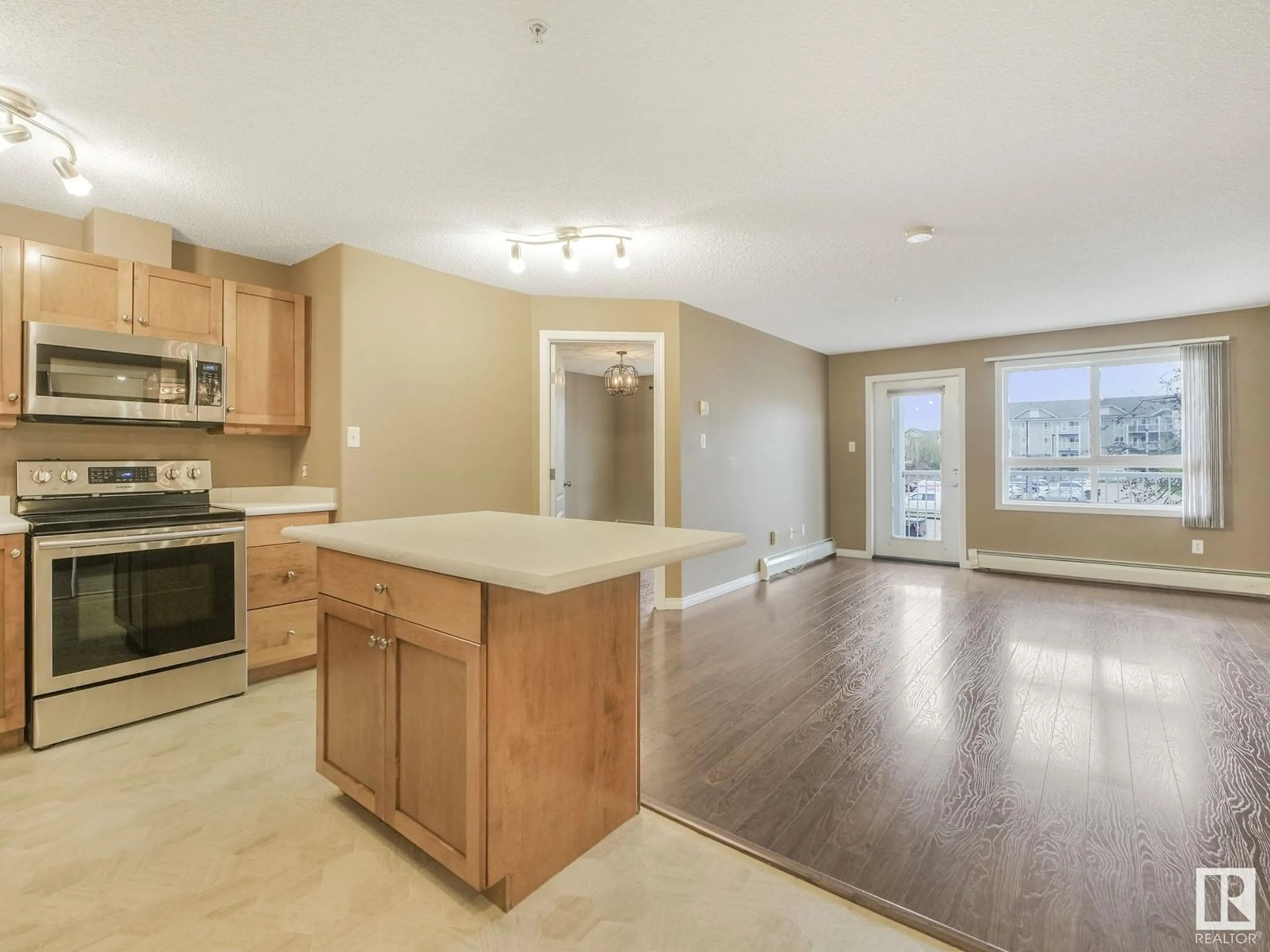Open concept kitchen, wood/laminate floor for #224 - 5340 199 ST, Edmonton Alberta T6M0A5