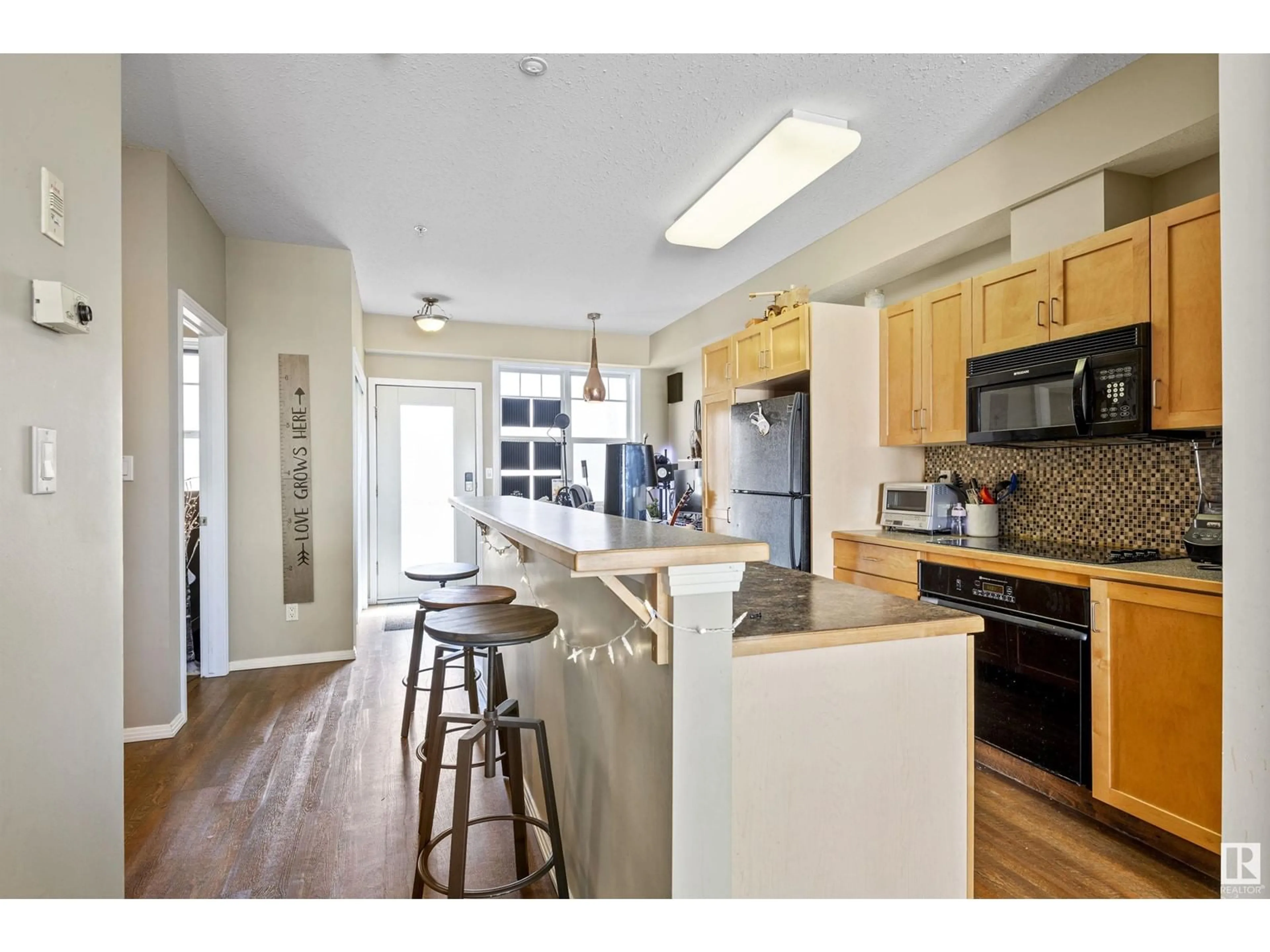 Open concept kitchen, wood/laminate floor for #308 - 9828 112 ST, Edmonton Alberta T5K1L4