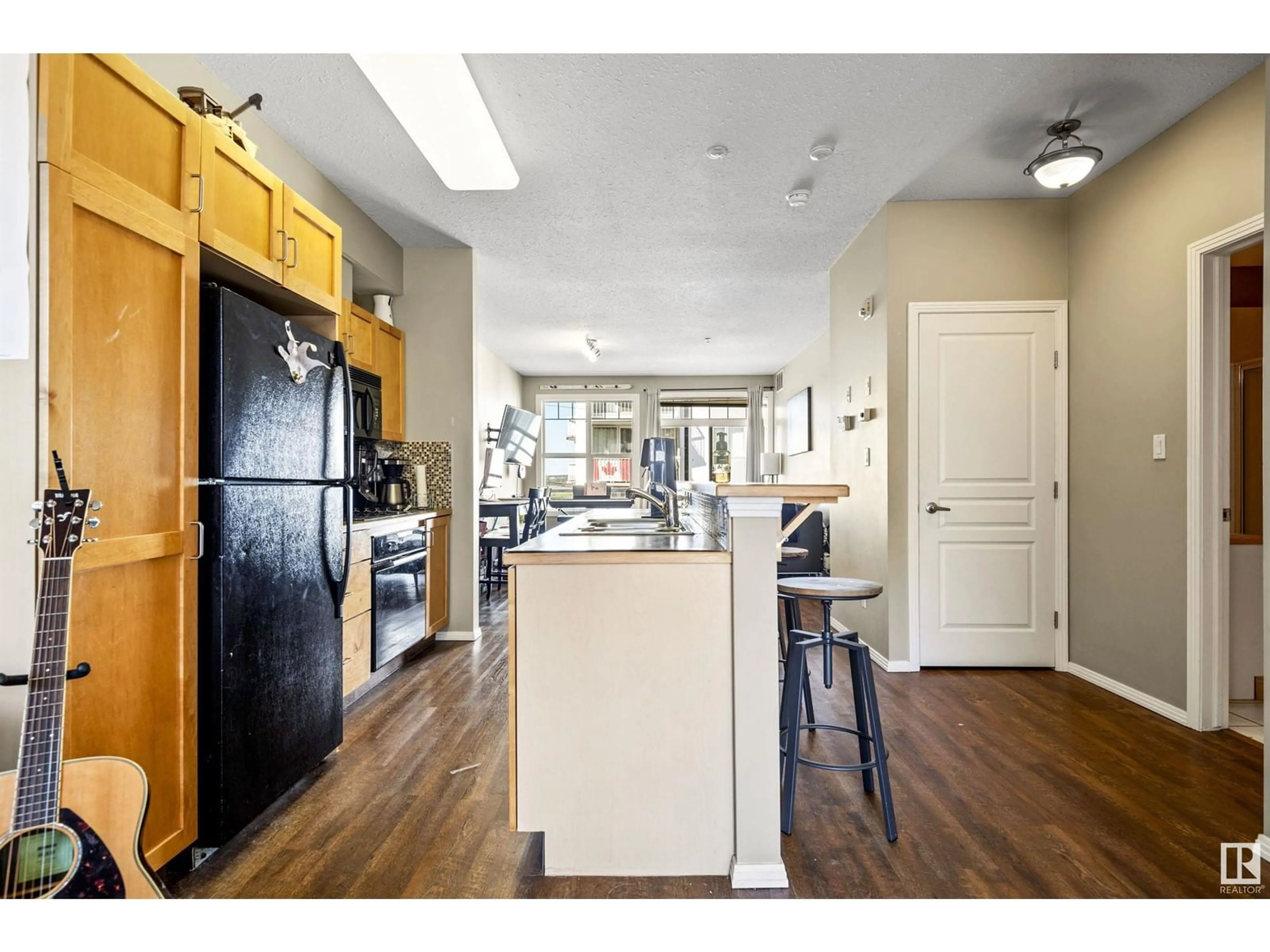 Open concept kitchen, wood/laminate floor for #308 - 9828 112 ST, Edmonton Alberta T5K1L4