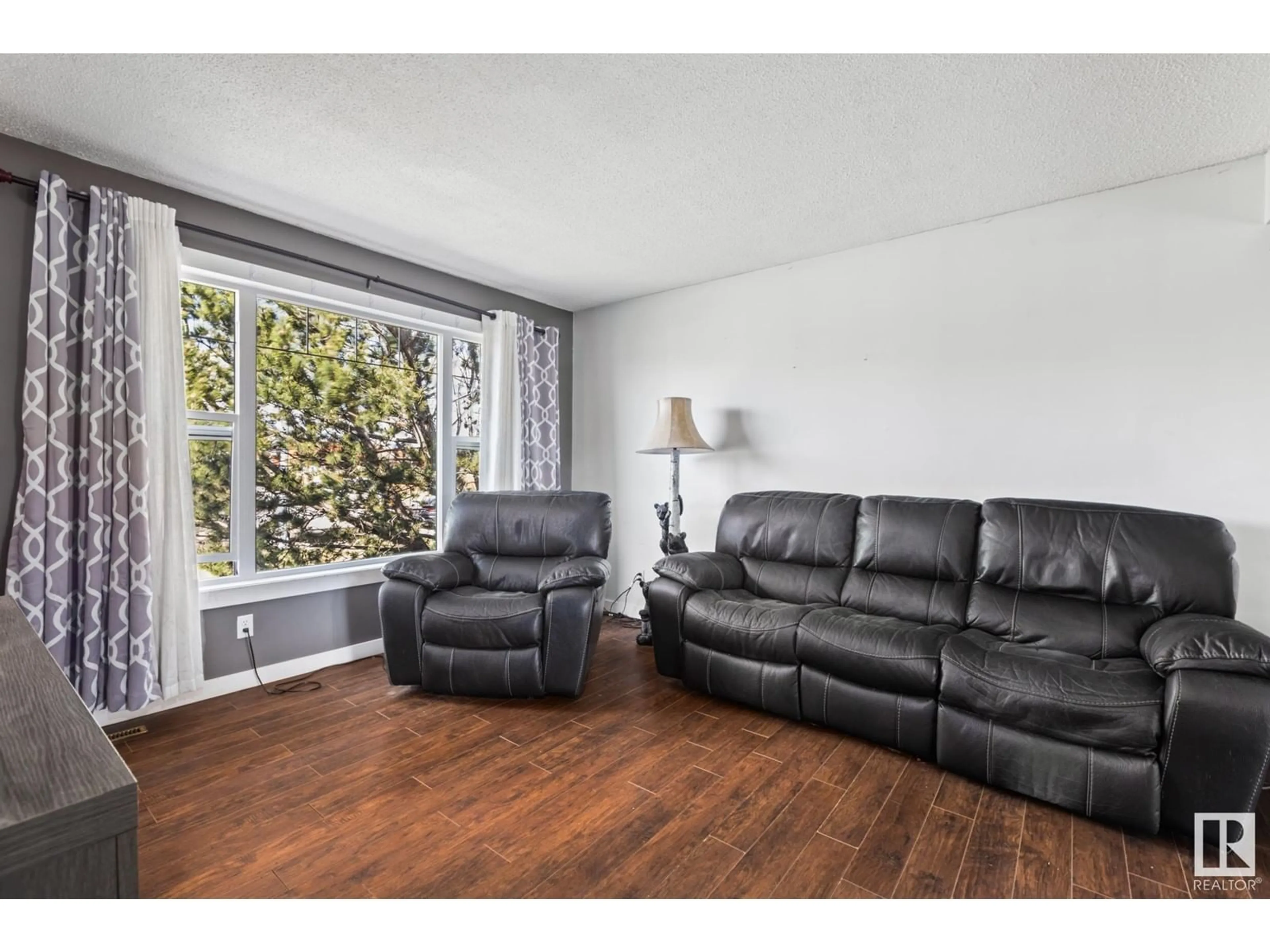 Living room with furniture, wood/laminate floor for 7111 130A AV, Edmonton Alberta T5C1Y8