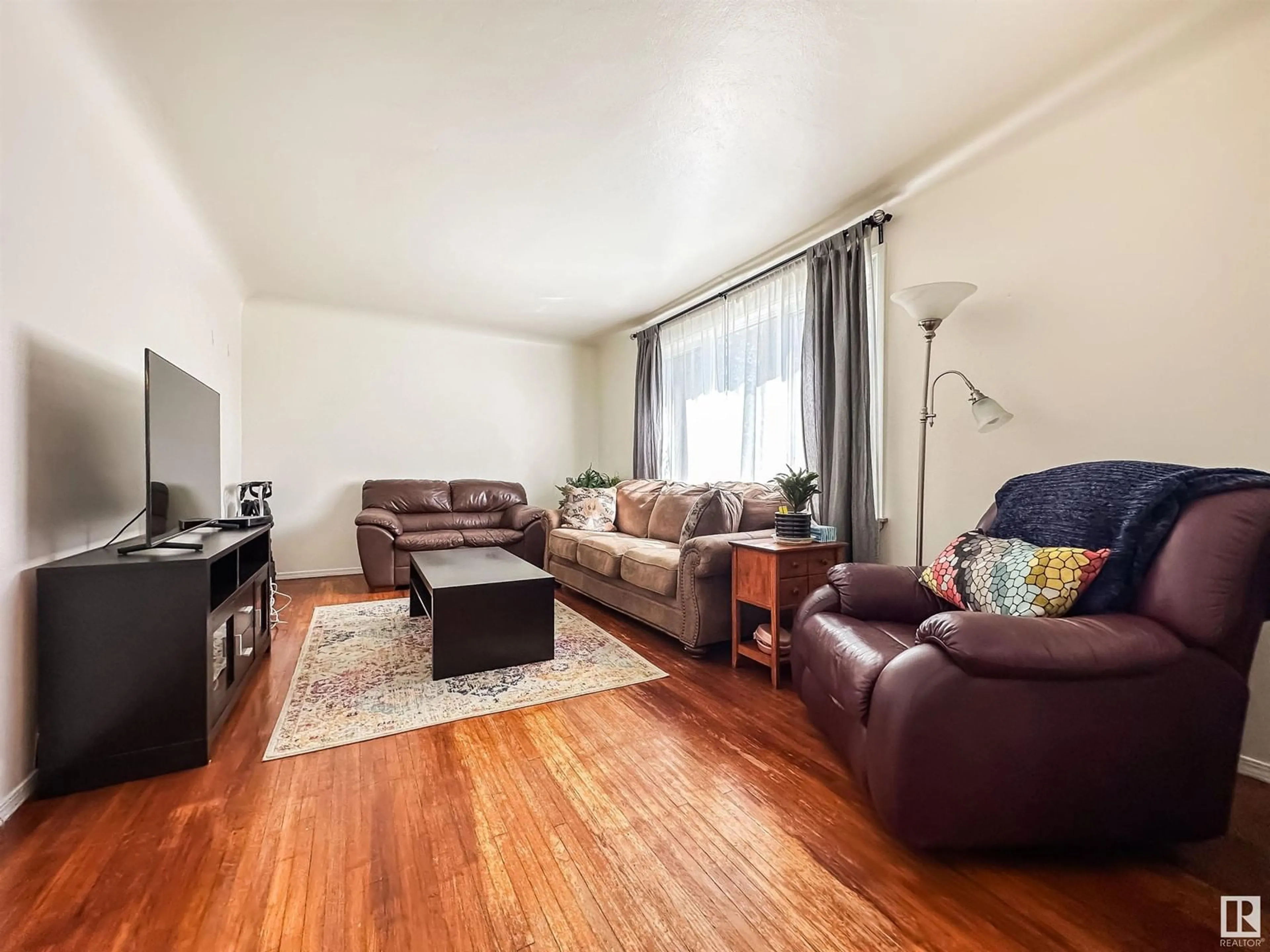 Living room with furniture, wood/laminate floor for 9352 85 ST, Edmonton Alberta T6C3C8