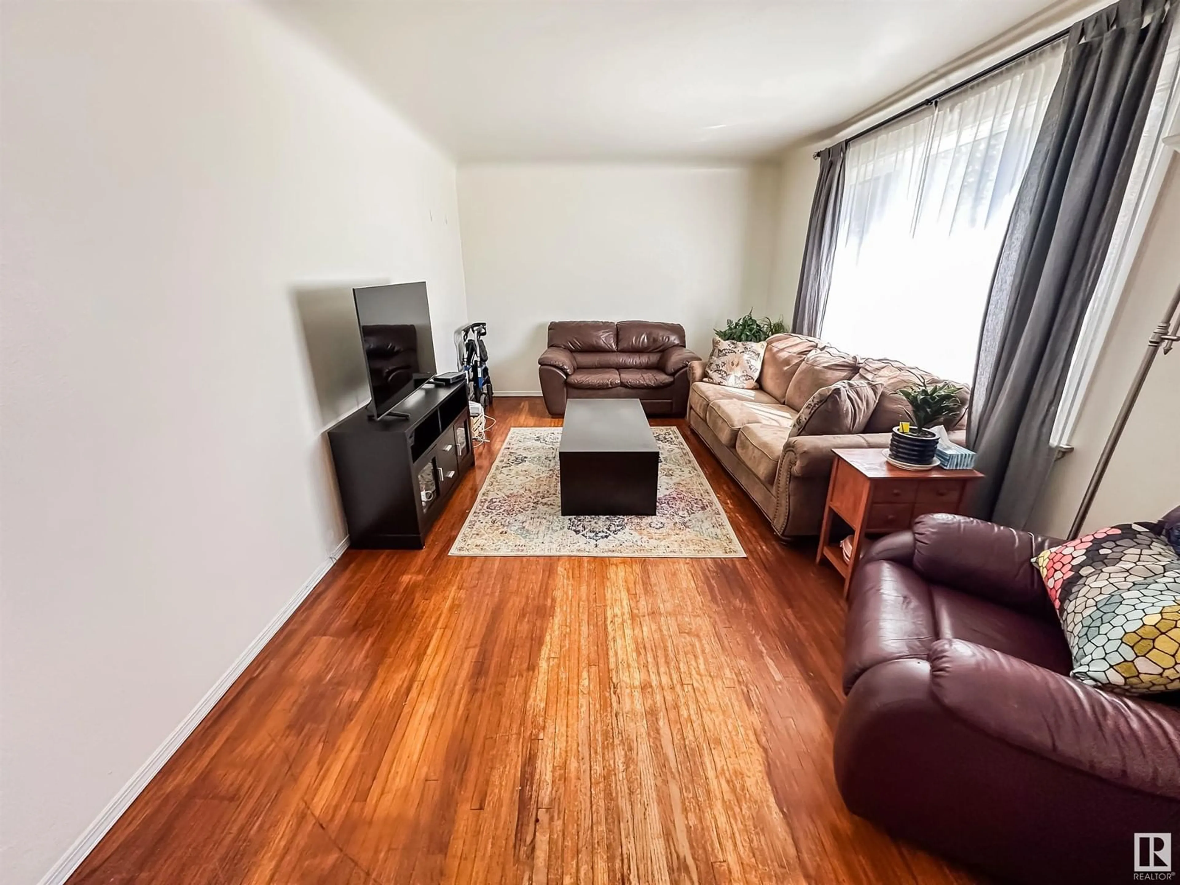 Living room with furniture, wood/laminate floor for 9352 85 ST, Edmonton Alberta T6C3C8