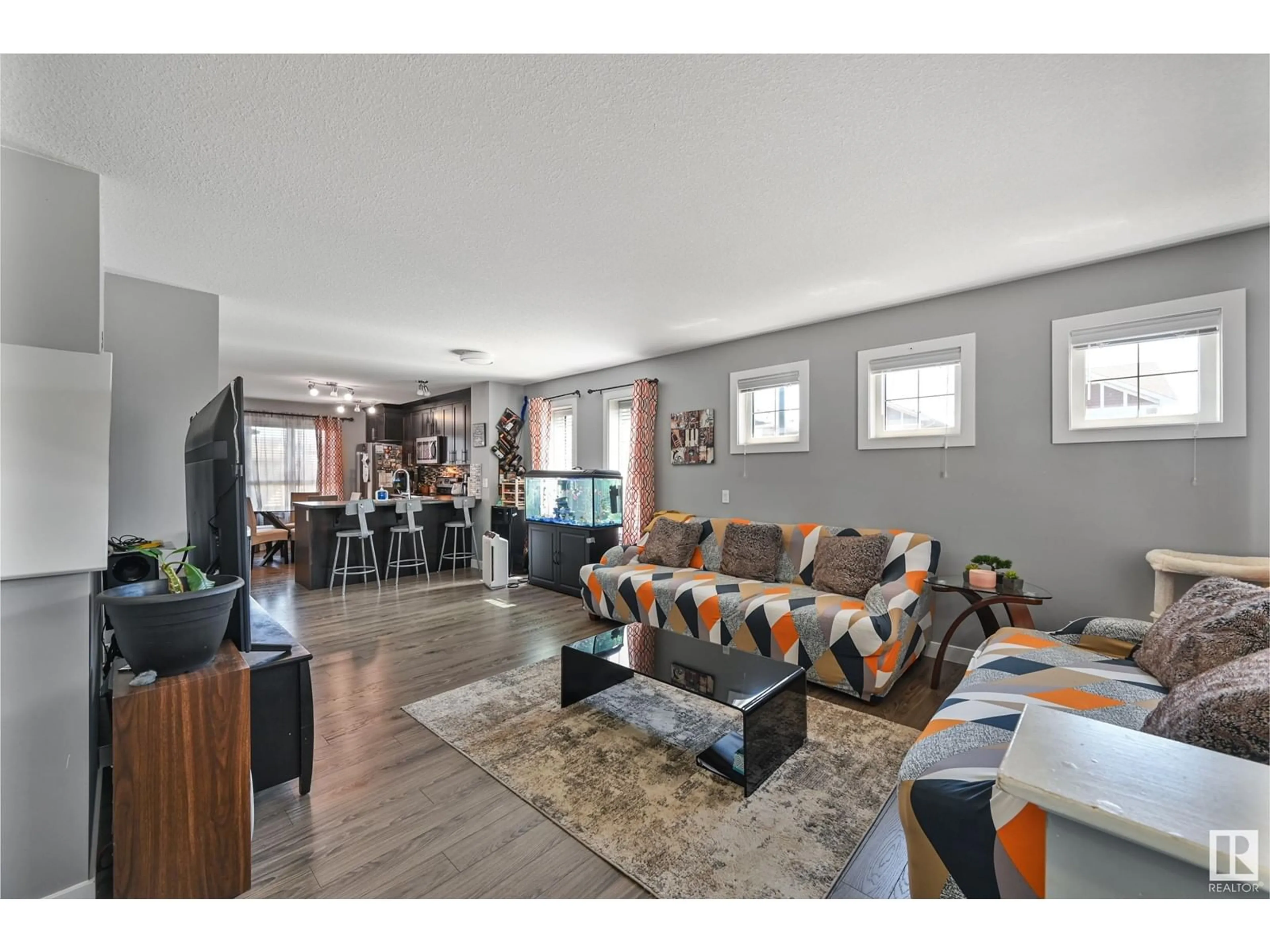 Living room with furniture, wood/laminate floor for 7303 EDGEMONT WY, Edmonton Alberta T6M0T7