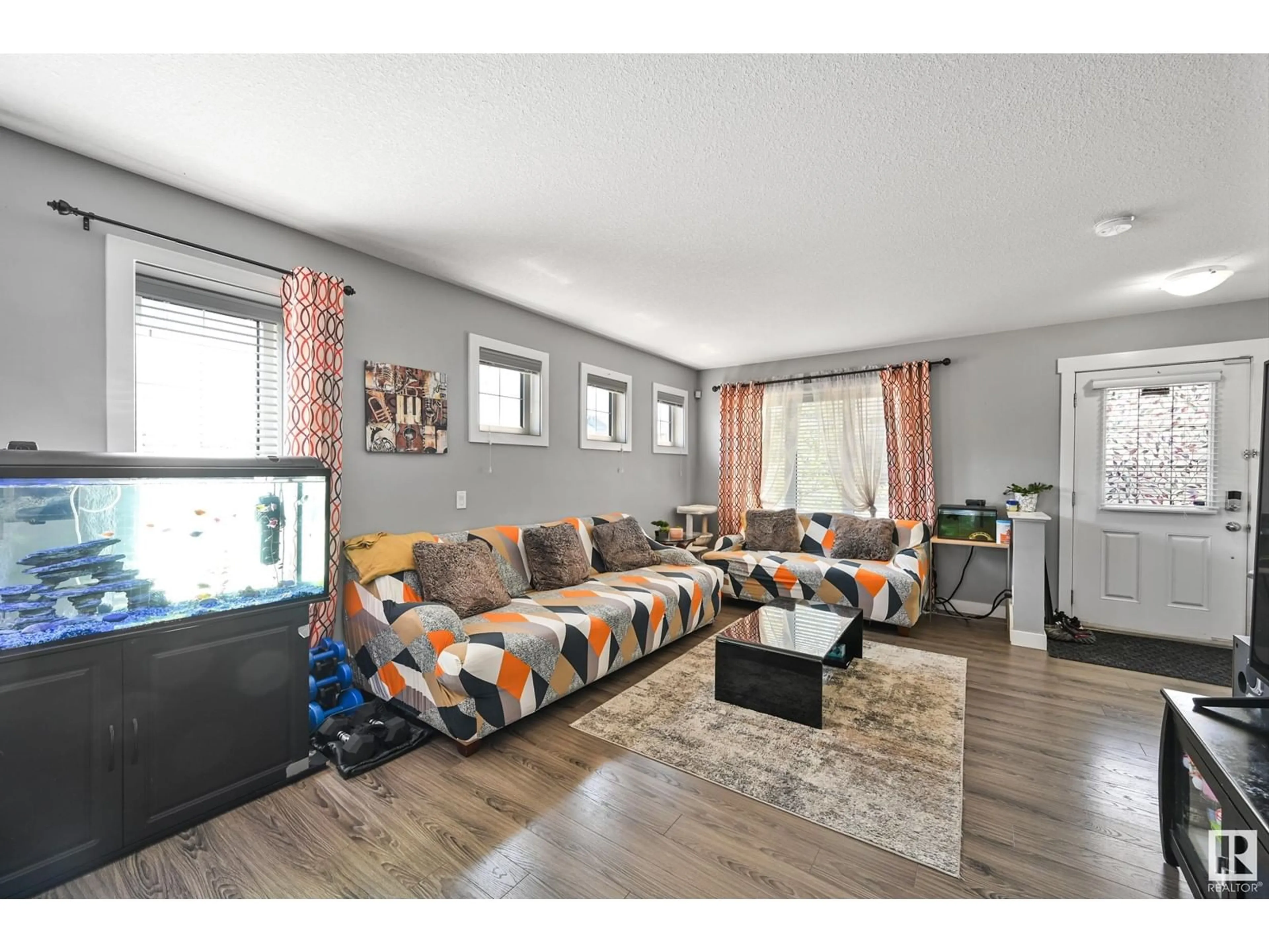Living room with furniture, wood/laminate floor for 7303 EDGEMONT WY, Edmonton Alberta T6M0T7