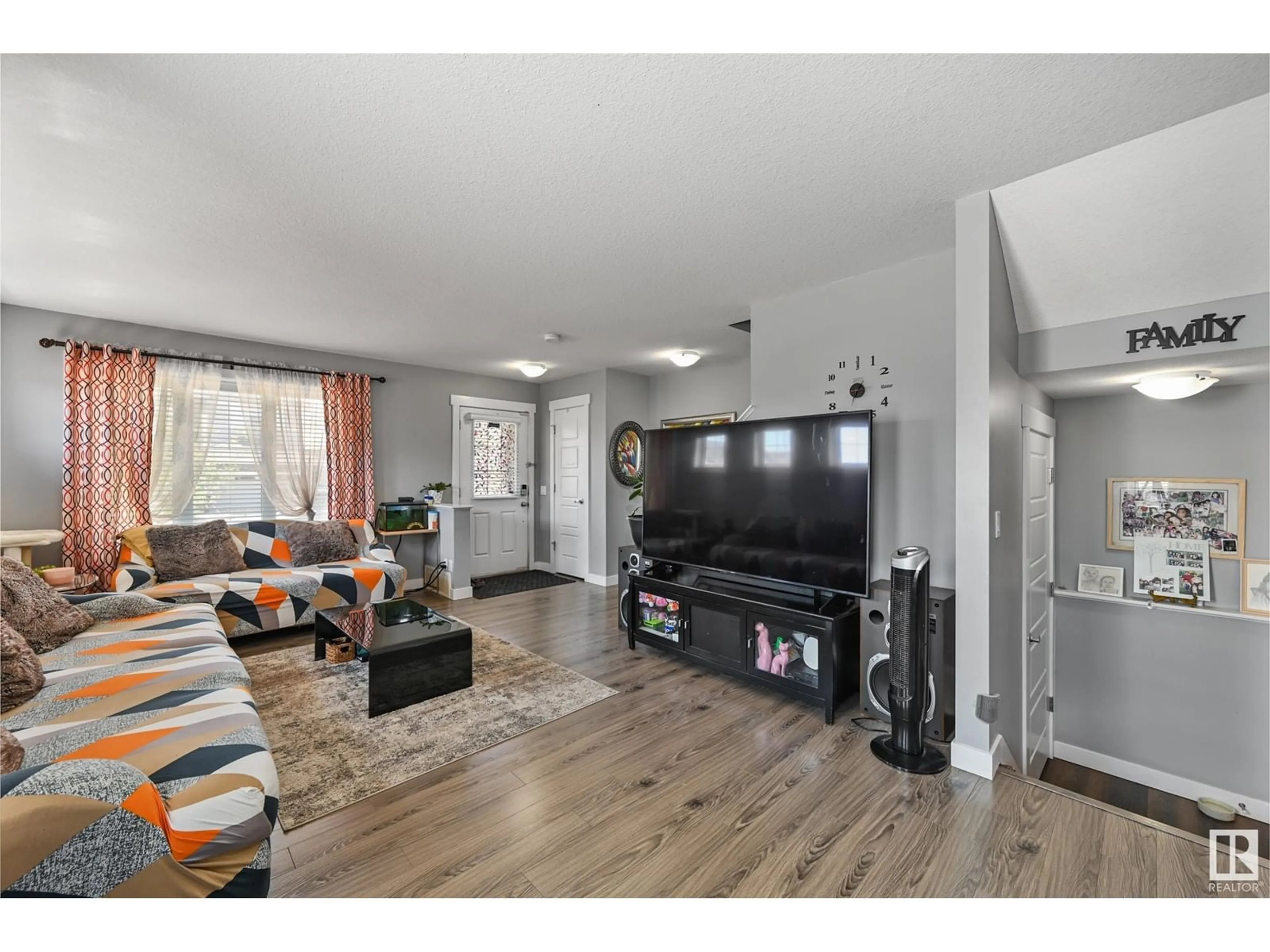 Living room with furniture, wood/laminate floor for 7303 EDGEMONT WY, Edmonton Alberta T6M0T7