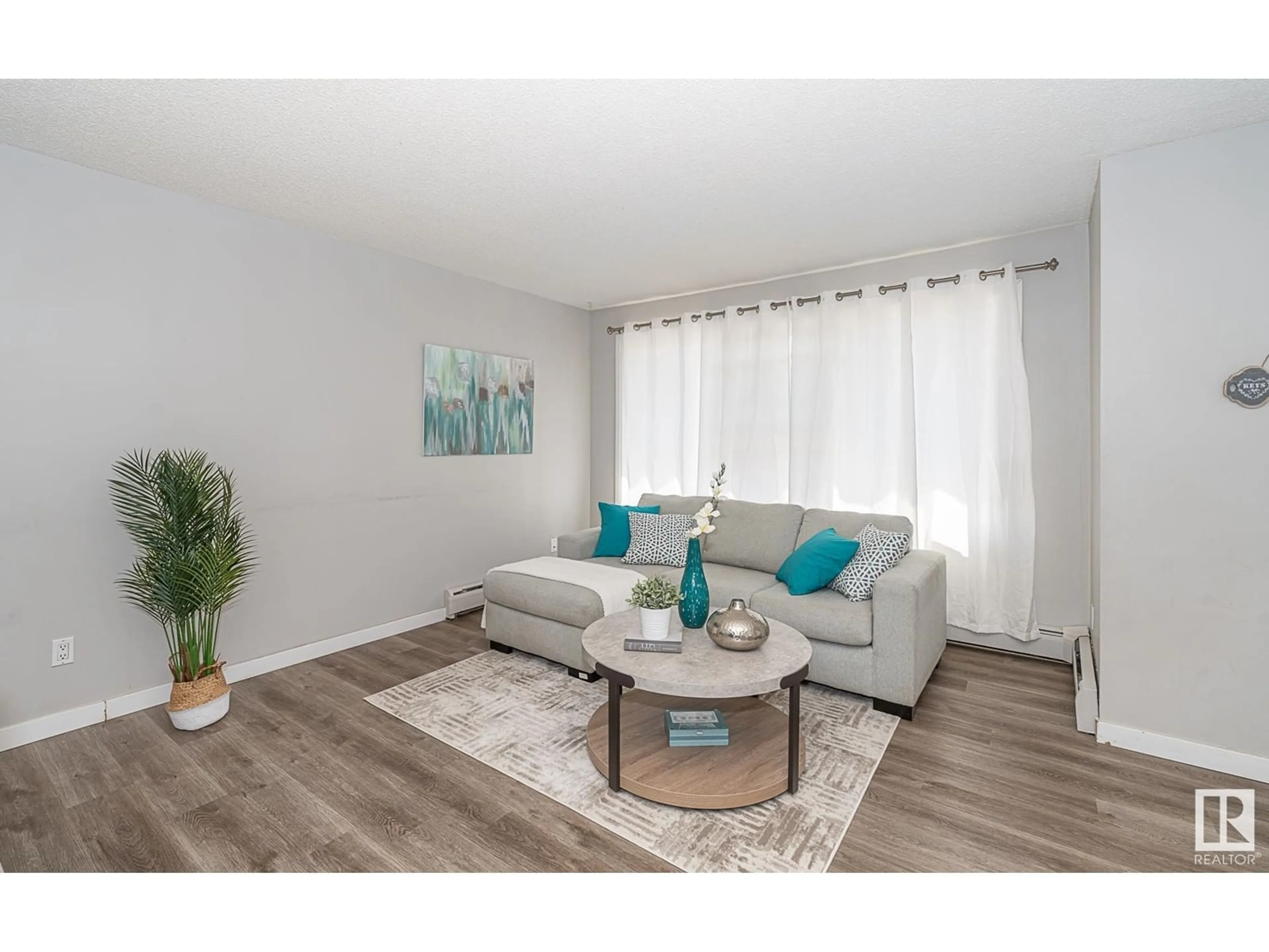 Living room with furniture, wood/laminate floor for #4 - 13570 38 ST, Edmonton Alberta T5A2W7