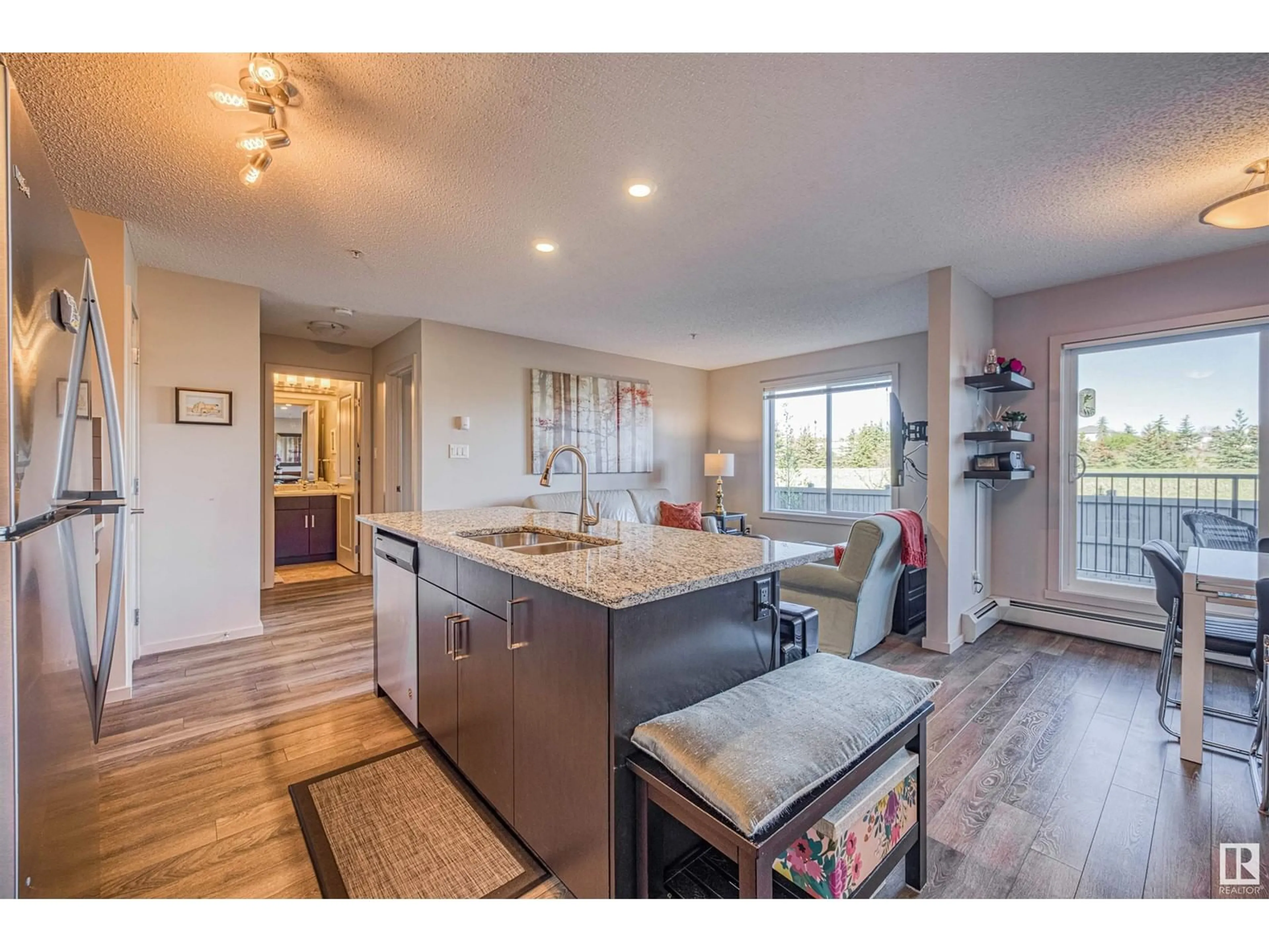 Open concept kitchen, wood/laminate floor for #211 - 211 EBBERS BV, Edmonton Alberta T5Y3W2